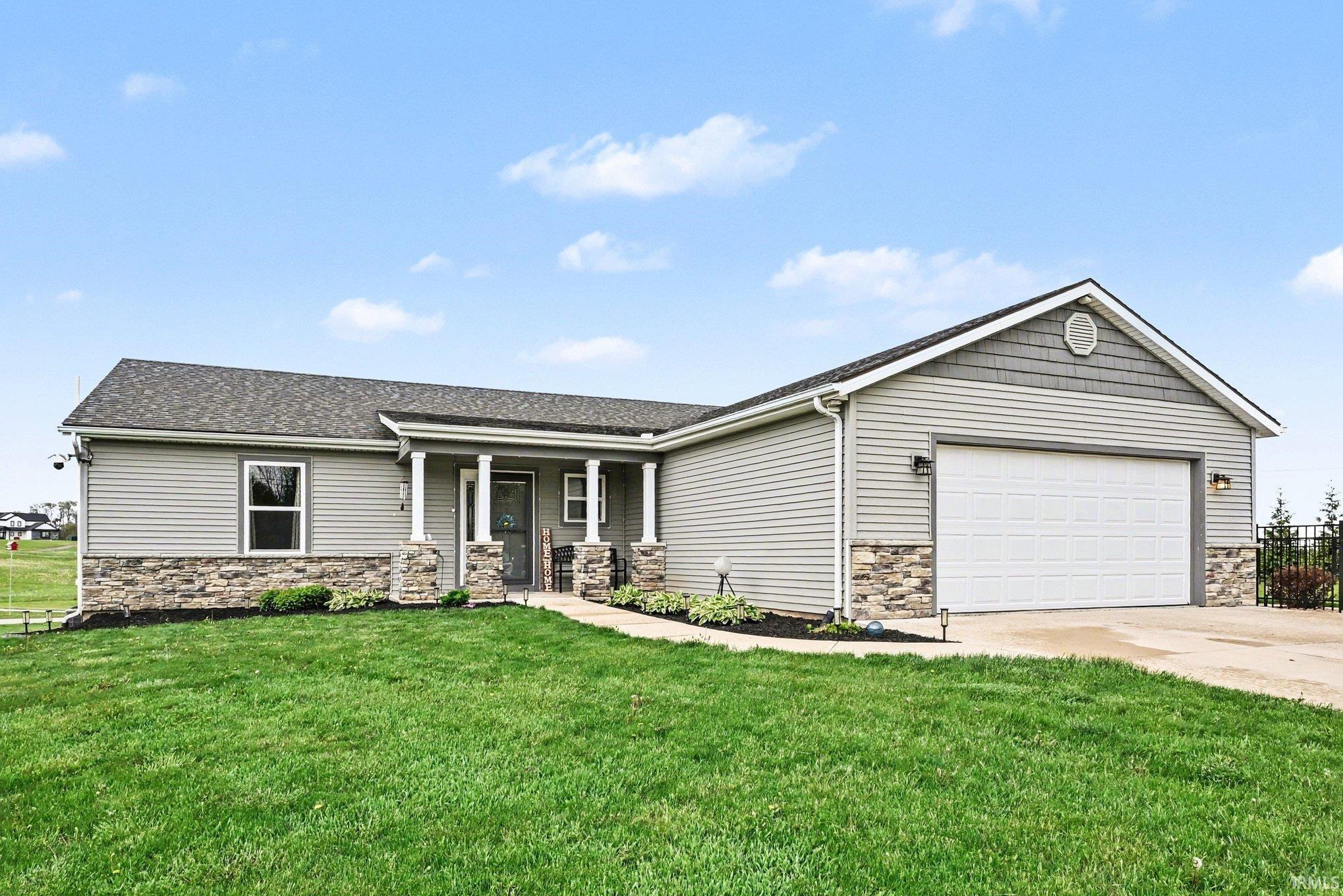 Ranch-style exterior featuring light gray horizontal siding and stone veneer accents