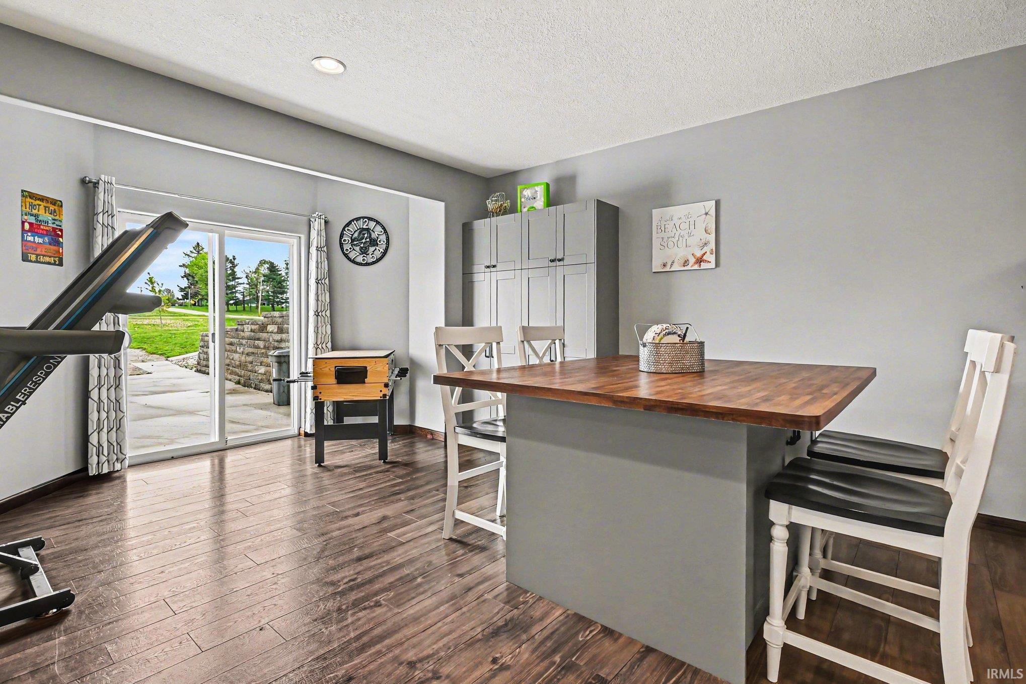 Spacious room featuring wood-finish flooring and light gray walls