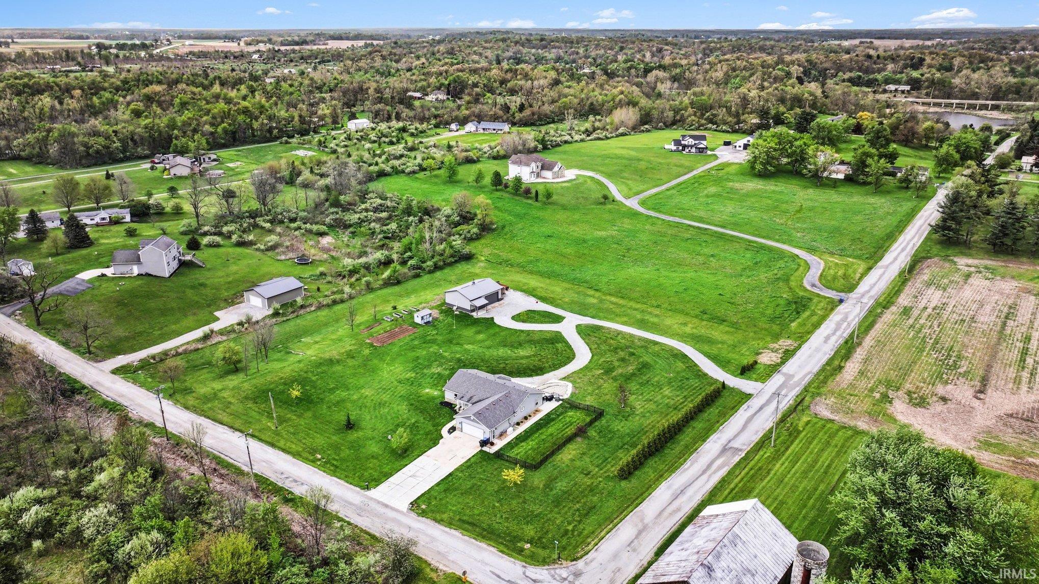 Expansive residential property featuring multiple residences, extensive green spaces, a paved driveway, and mature landscaping