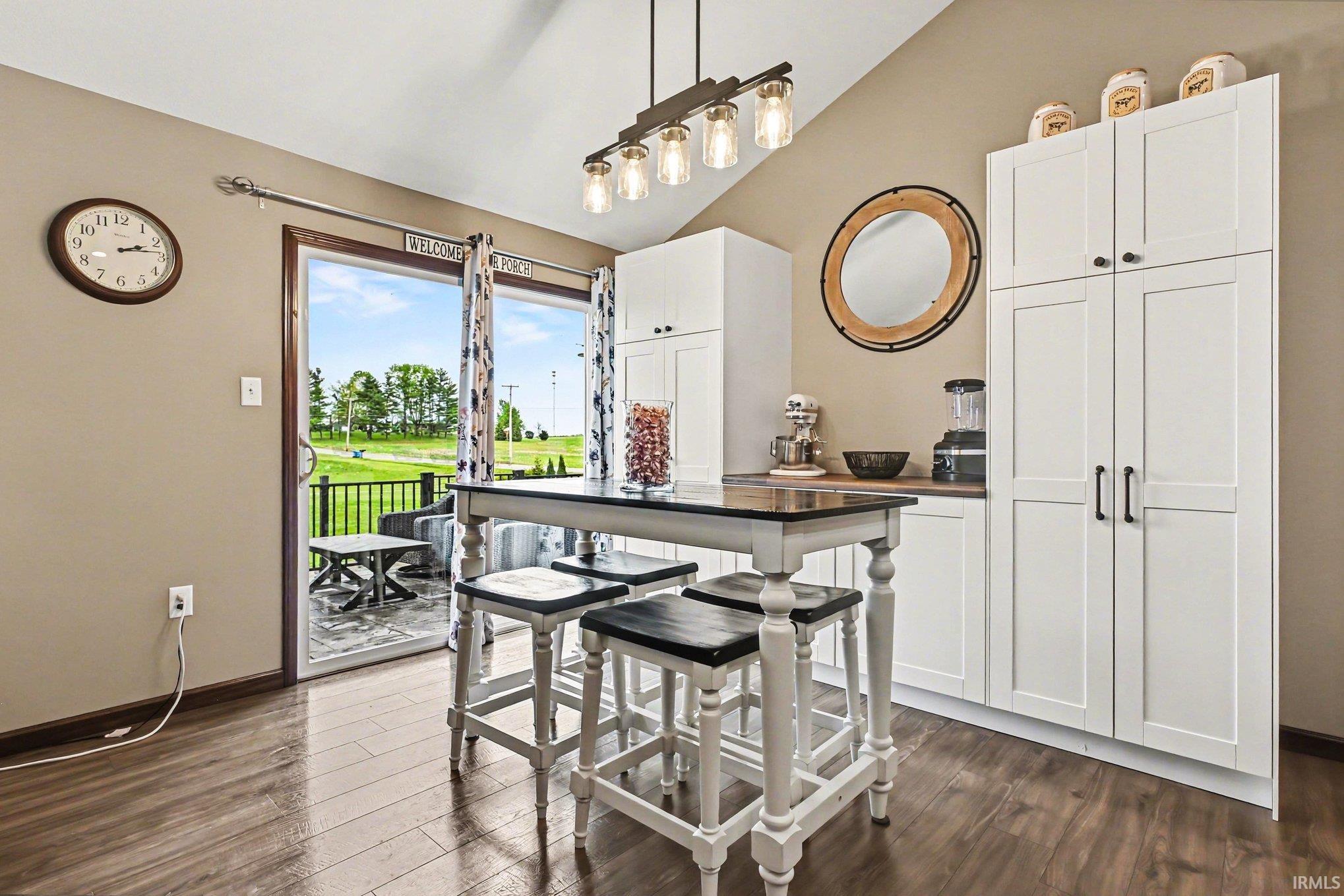 Kitchen area featuring wood-finish flooring, white cabinetry with black hardware, and a wood countertop