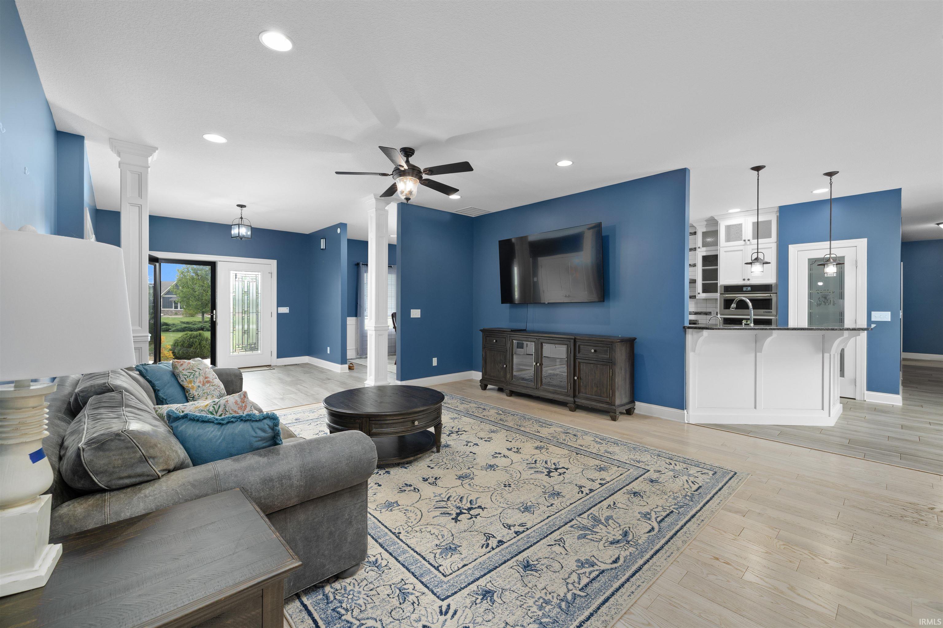 Open-concept living area featuring light wood-finish flooring, recessed lighting, and a ceiling fan