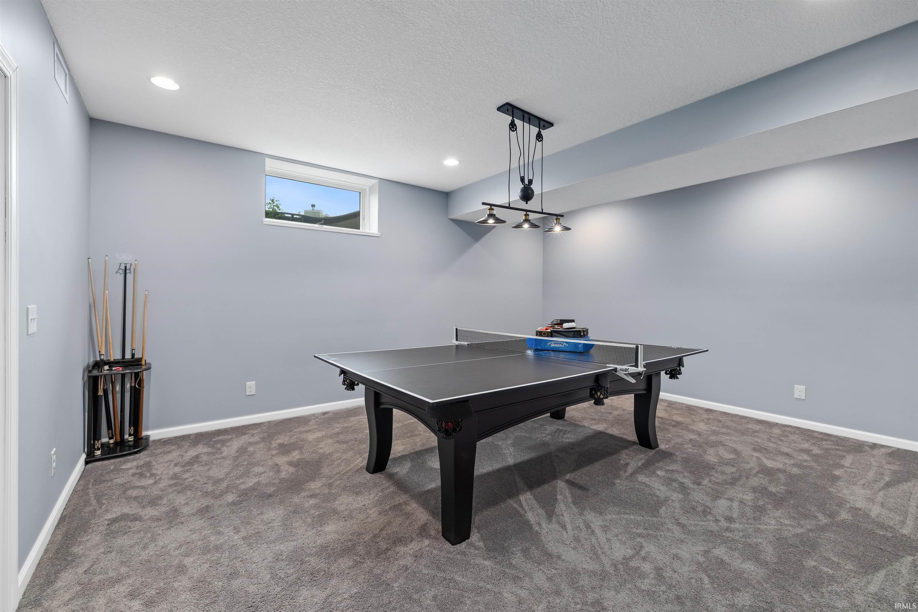 Recreation room featuring plush grey carpeting, recessed lighting, a horizontal window, and a modern track light fixture
