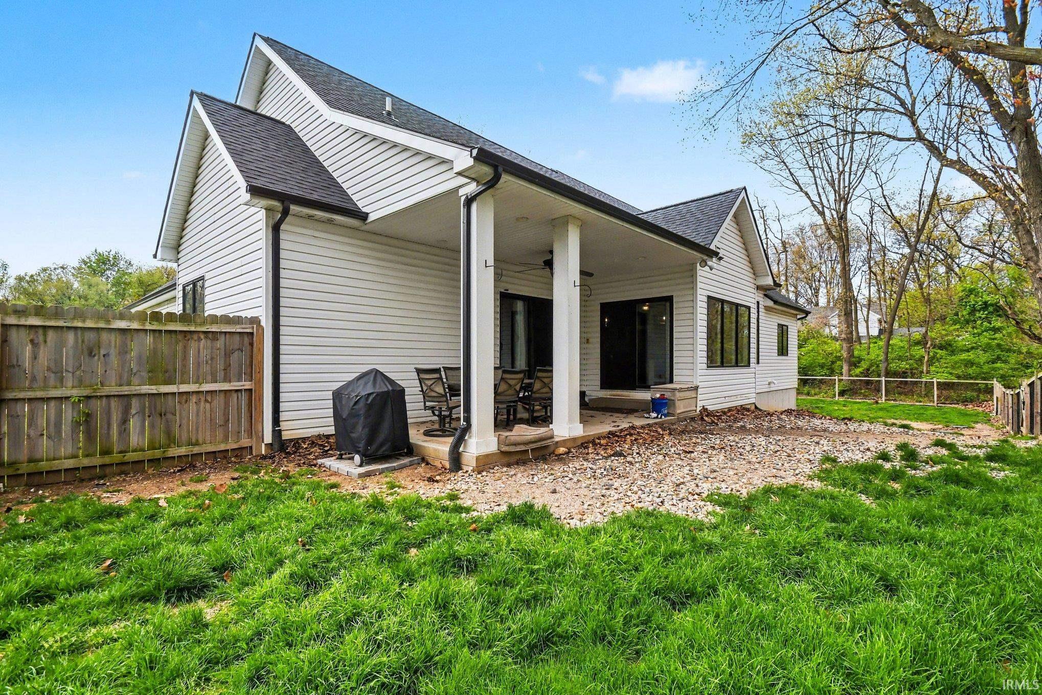 Modern white siding exterior with a dark shingle roof and black gutters