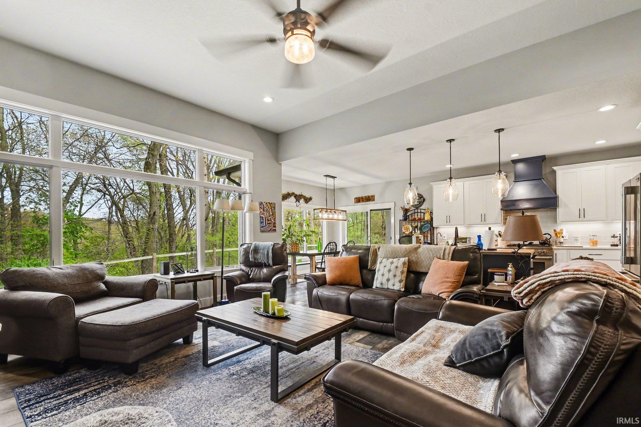 Open-concept living space featuring expansive windows, recessed lighting, and a ceiling fan