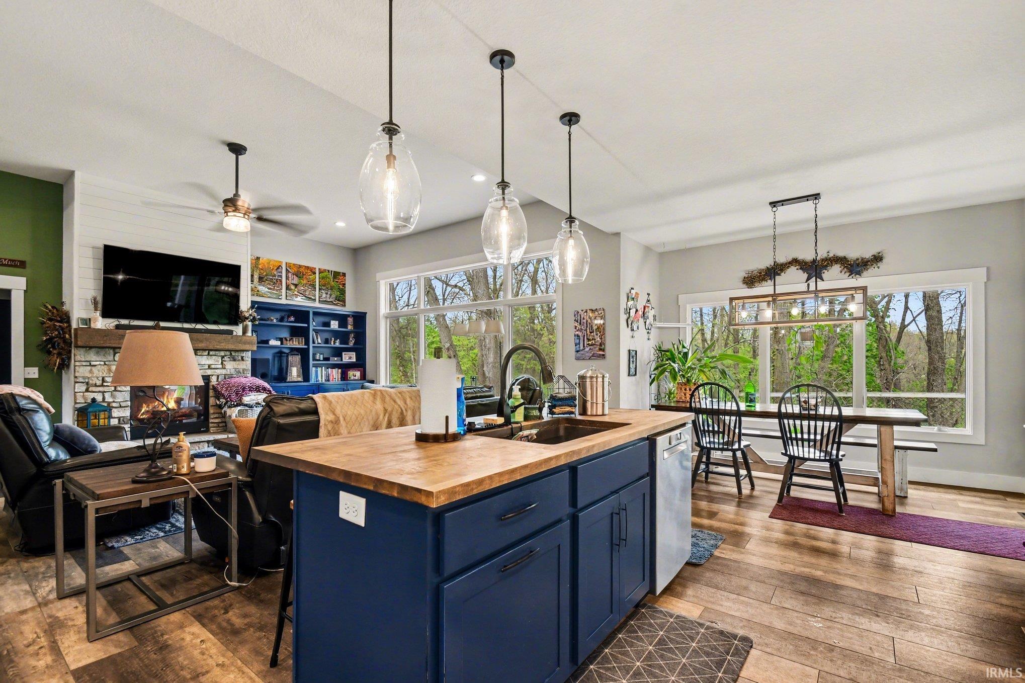 Kitchen island featuring a wood-finish countertop, undermount sink, and dark blue cabinetry