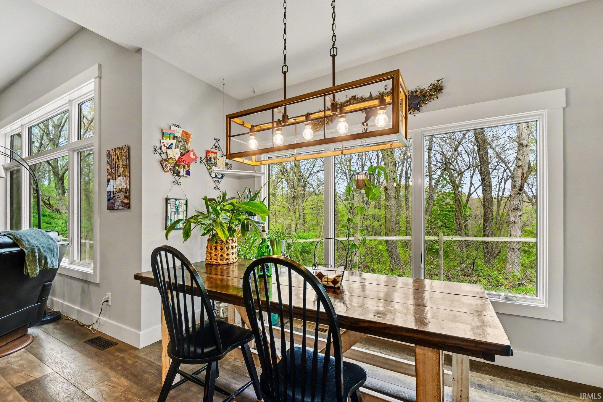 Dining area featuring wood-finish flooring, a vaulted ceiling, and white trim