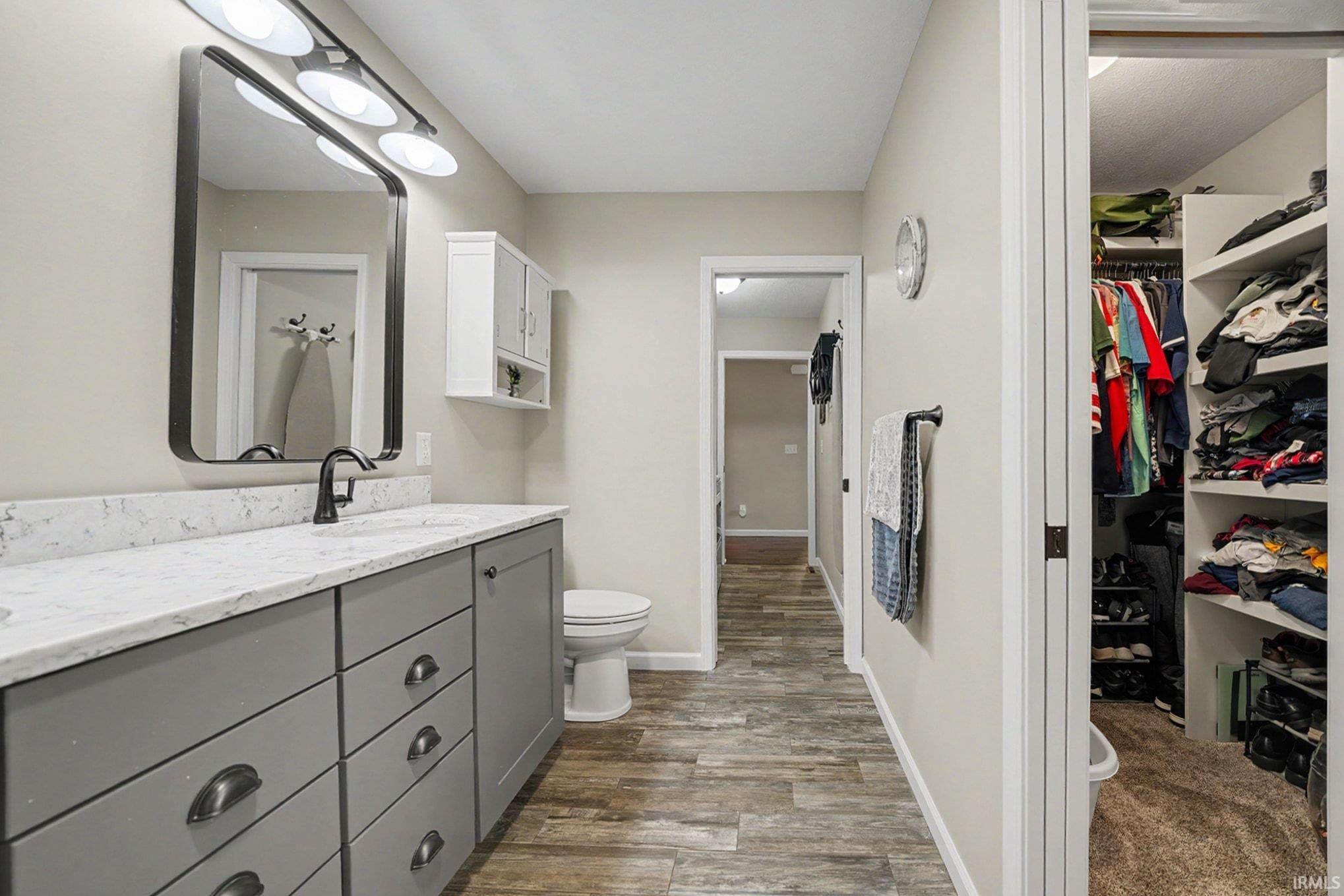 Bathroom featuring a single vanity with gray cabinetry, a white countertop, and a rectangular black-framed mirror