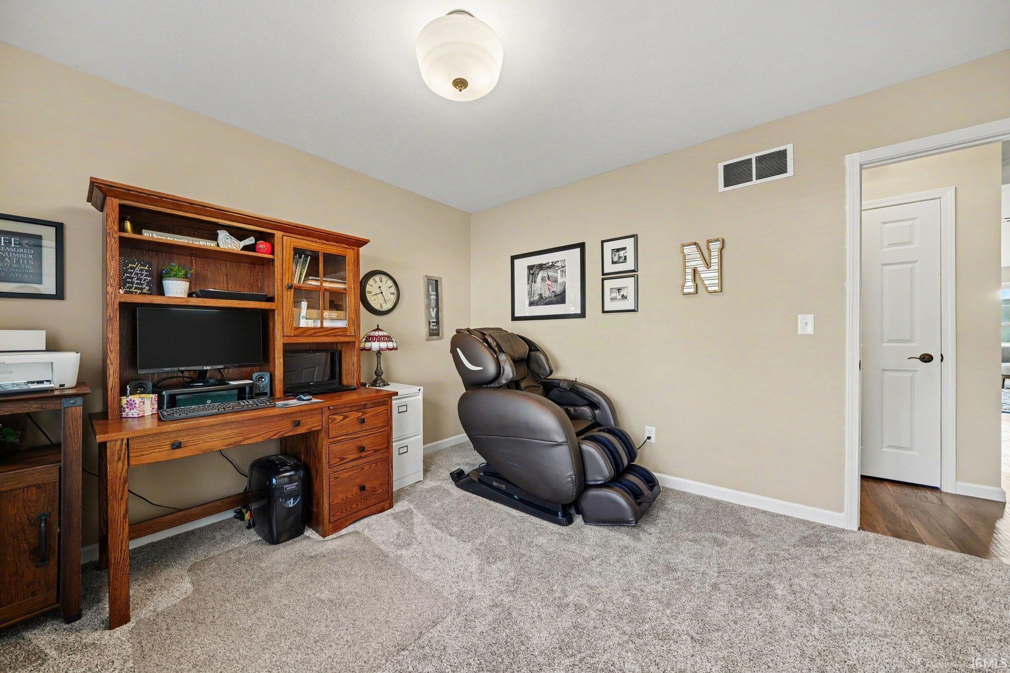 Room featuring light neutral wall paint and gray carpet flooring