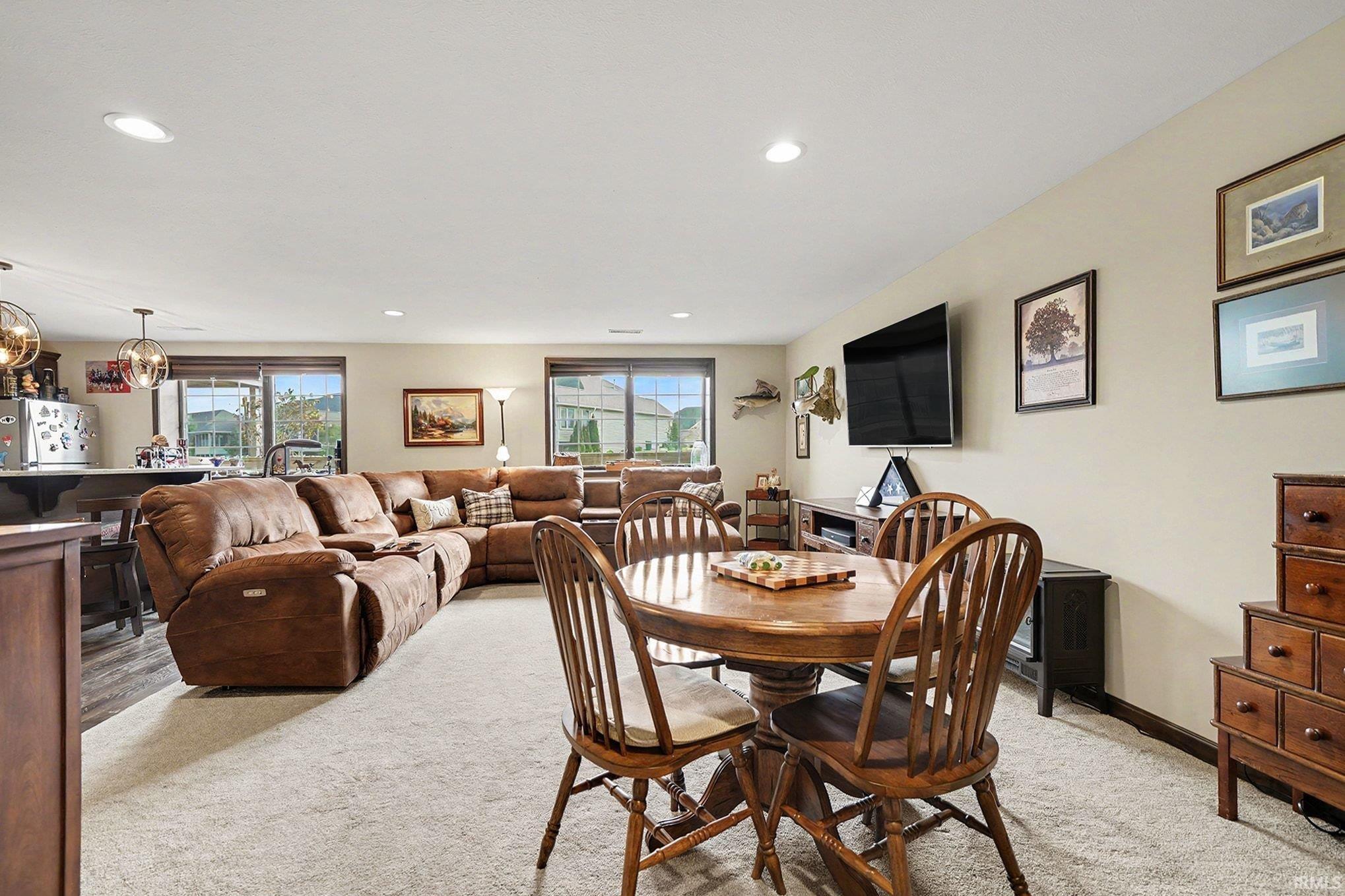 Open-concept living area featuring light-toned carpeting and recessed lighting