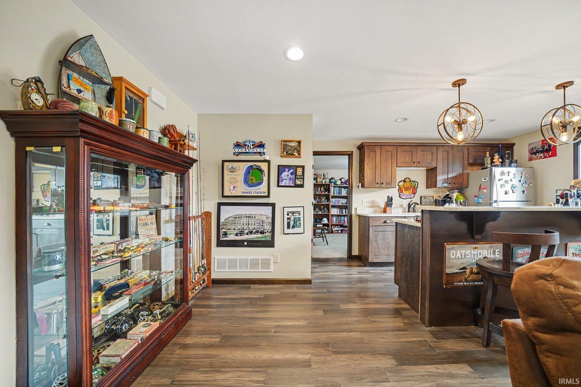 Open-concept living space featuring wood-finish flooring, recessed lighting, and a modern kitchen