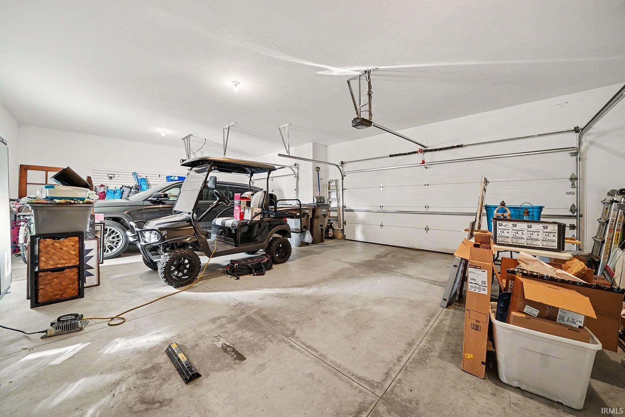Spacious garage featuring concrete flooring and two overhead garage doors