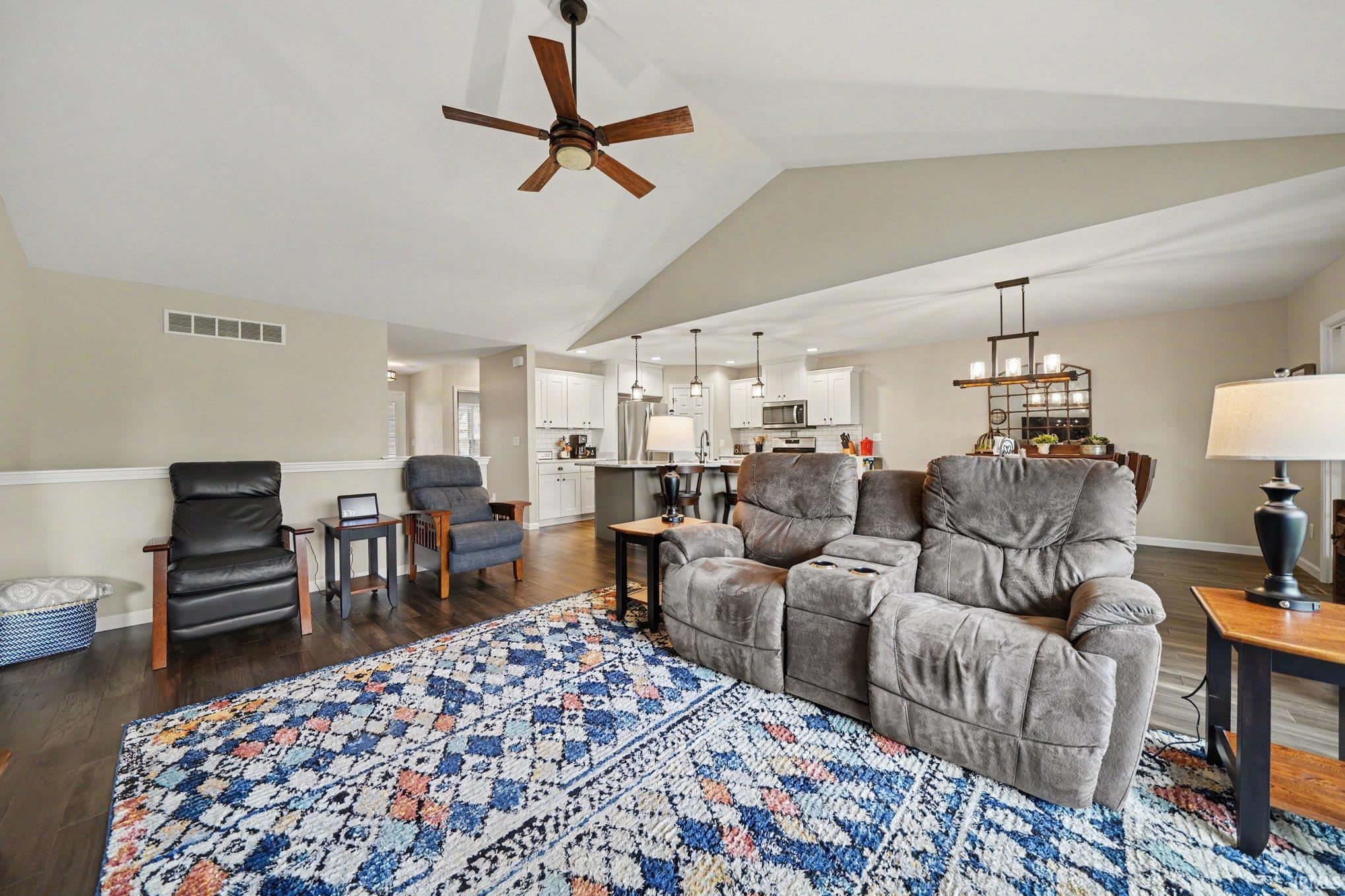 Vaulted ceiling living space with wood-finish flooring