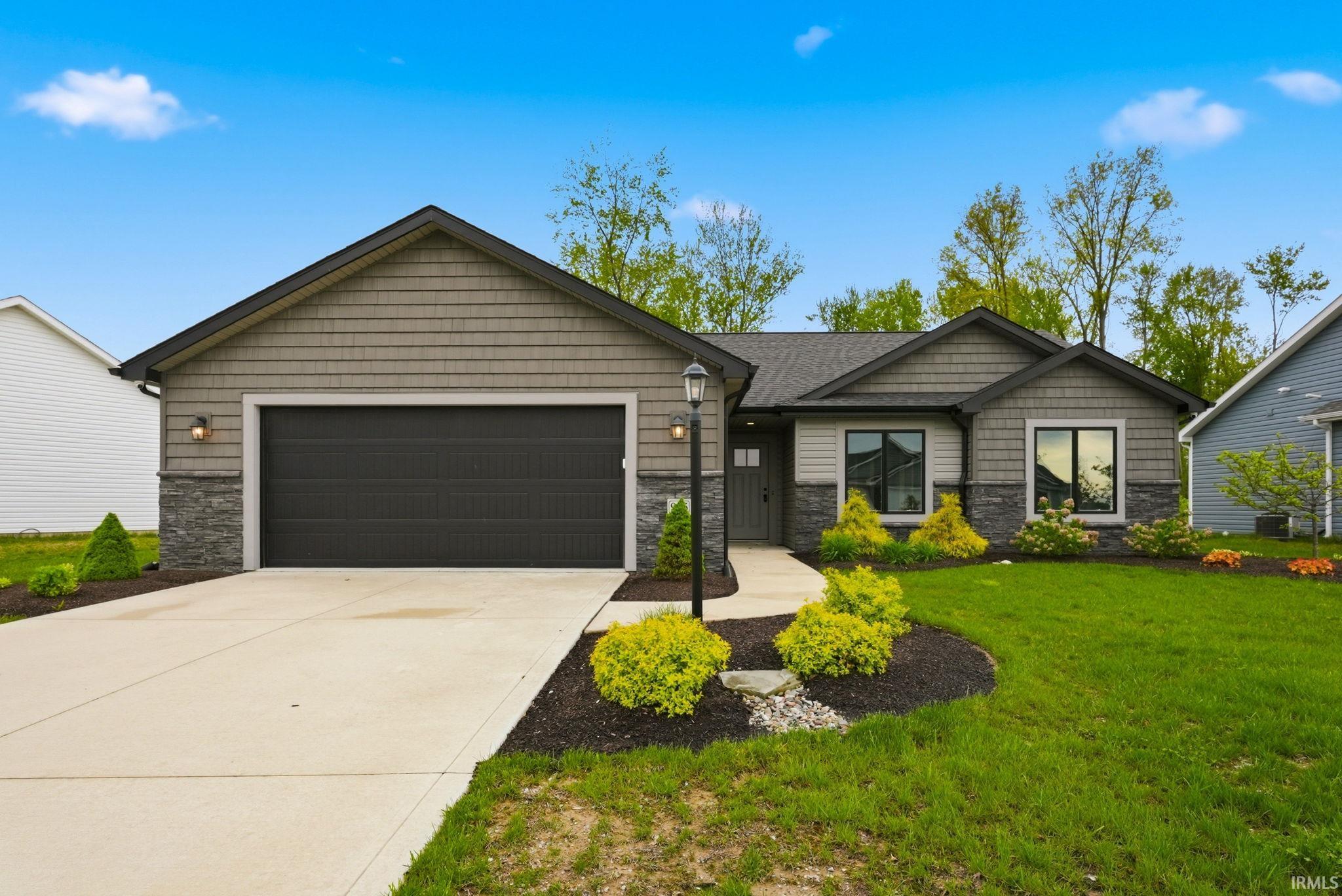 Contemporary ranch-style residence featuring a gray shingle and stone facade