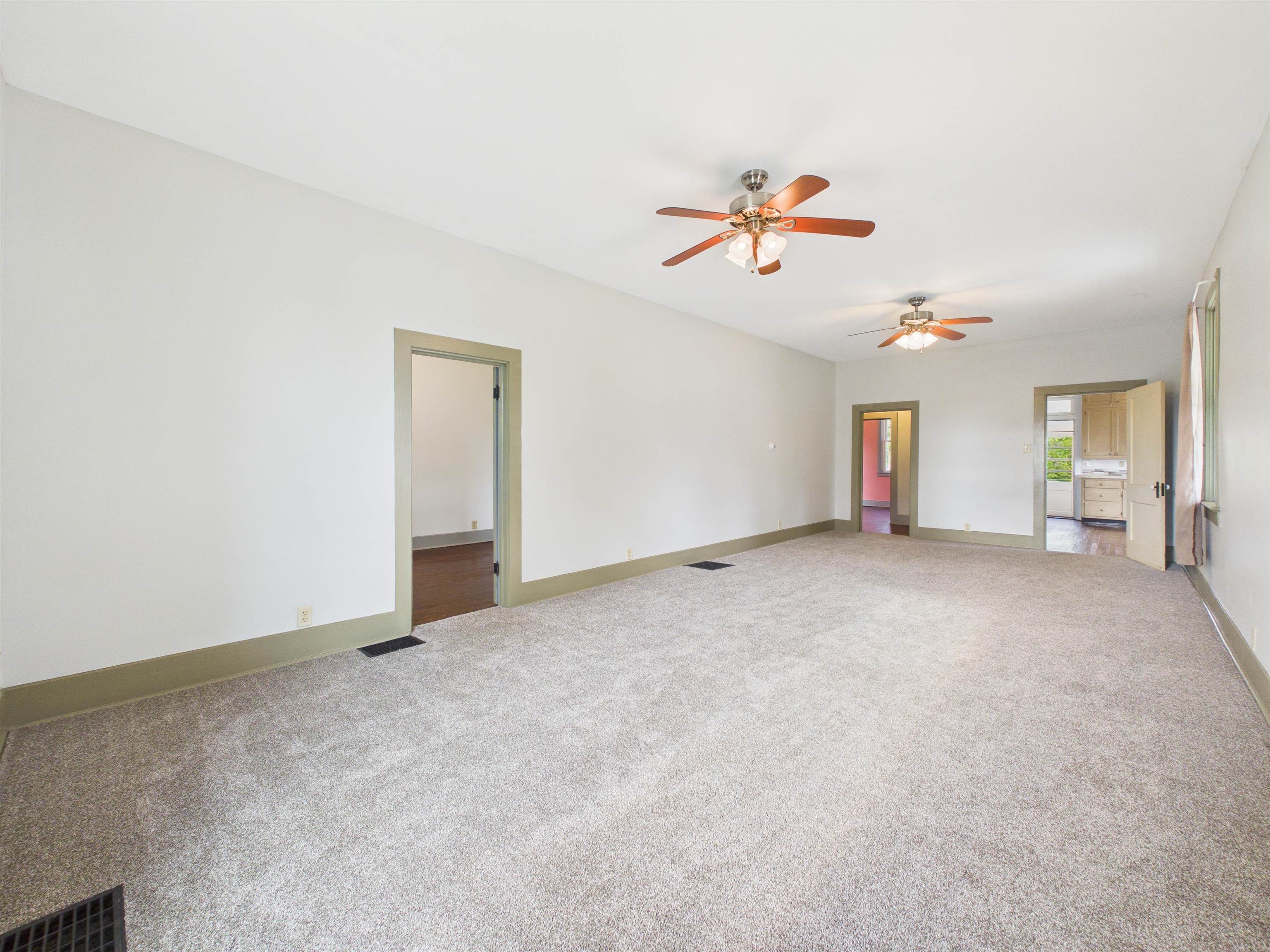Spacious interior featuring neutral carpet flooring, white walls, and dark trim