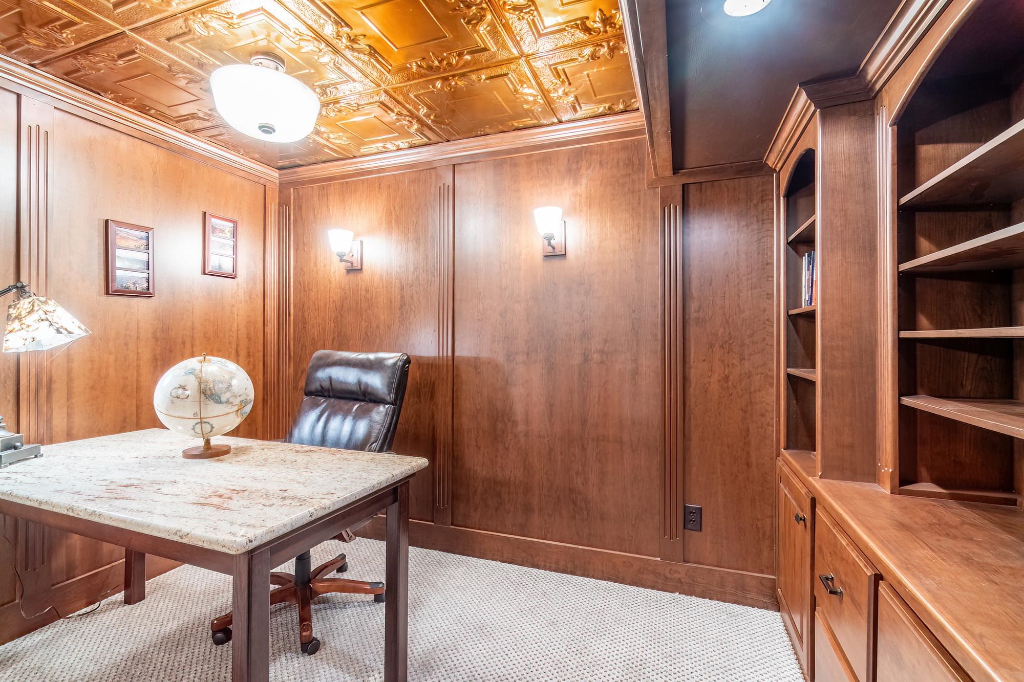 Wood-paneled room featuring a decorative pressed-tin ceiling
