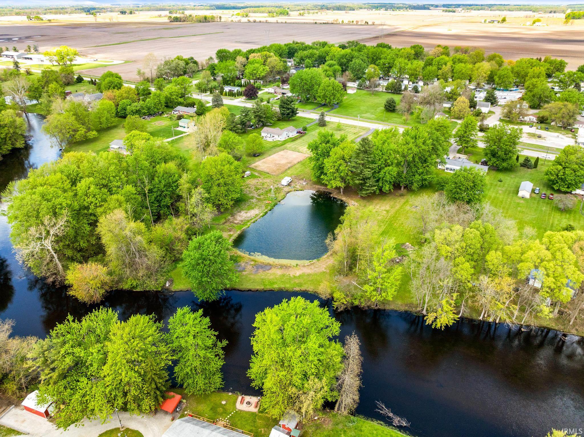 Expansive property featuring a dark-water pond and a river running alongside