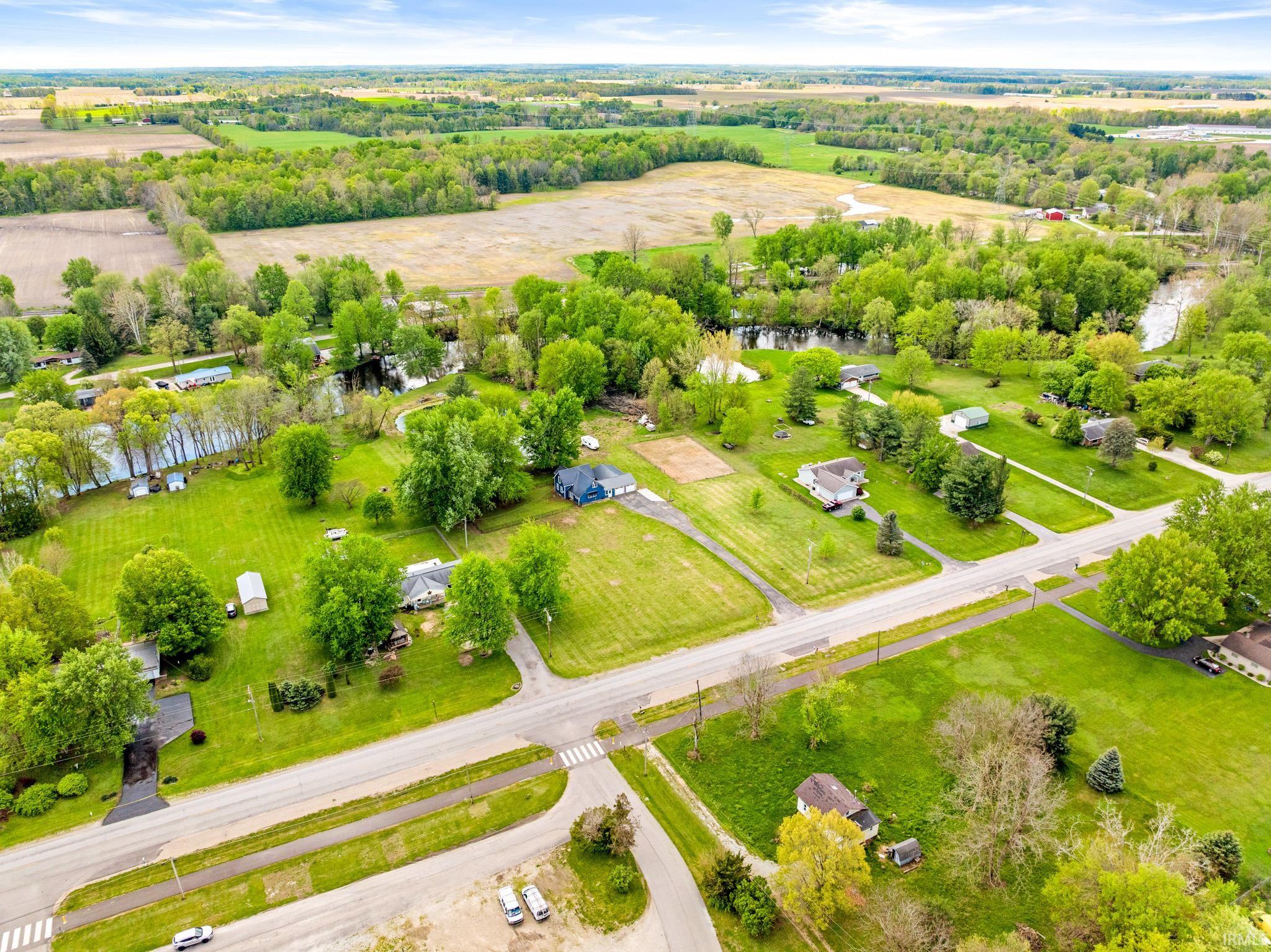 Aerial perspective showcasing expansive green spaces, mature trees, and a visible body of water
