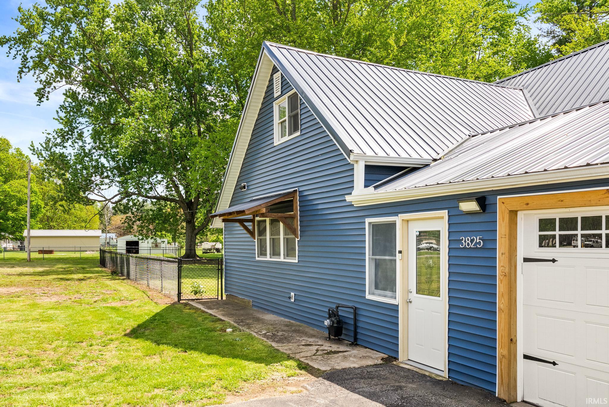 Blue horizontal siding exterior with a light-colored metal roof