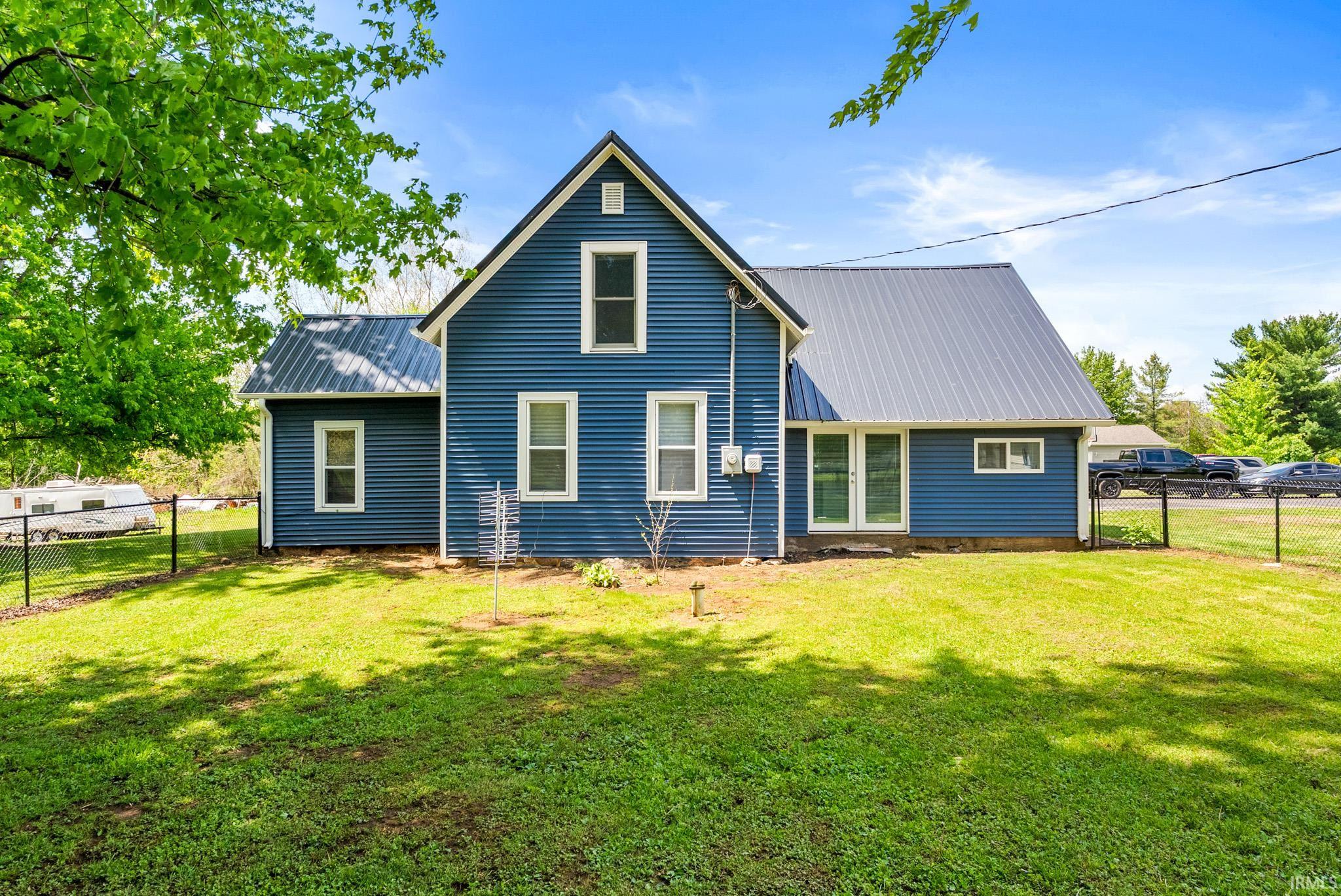 Blue siding exterior with a dark metal roof