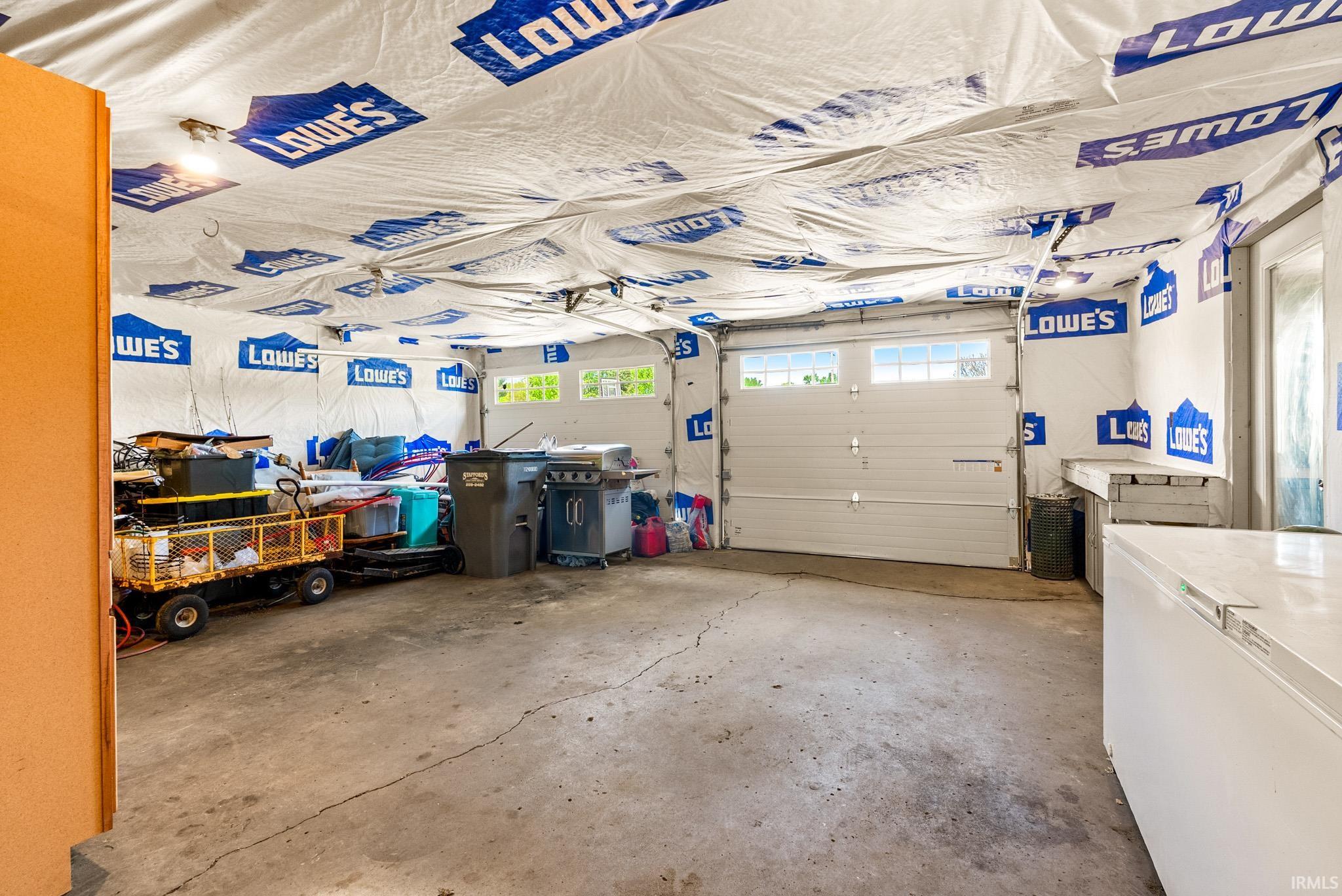 Spacious garage featuring a concrete floor and white garage door with upper window panels