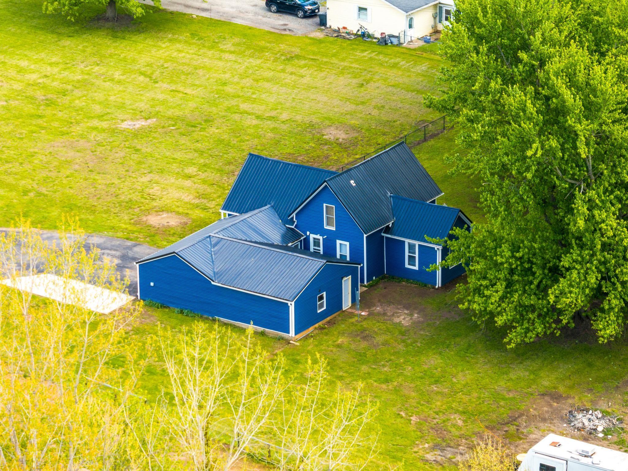 Blue-sided residence featuring a dark metal roof