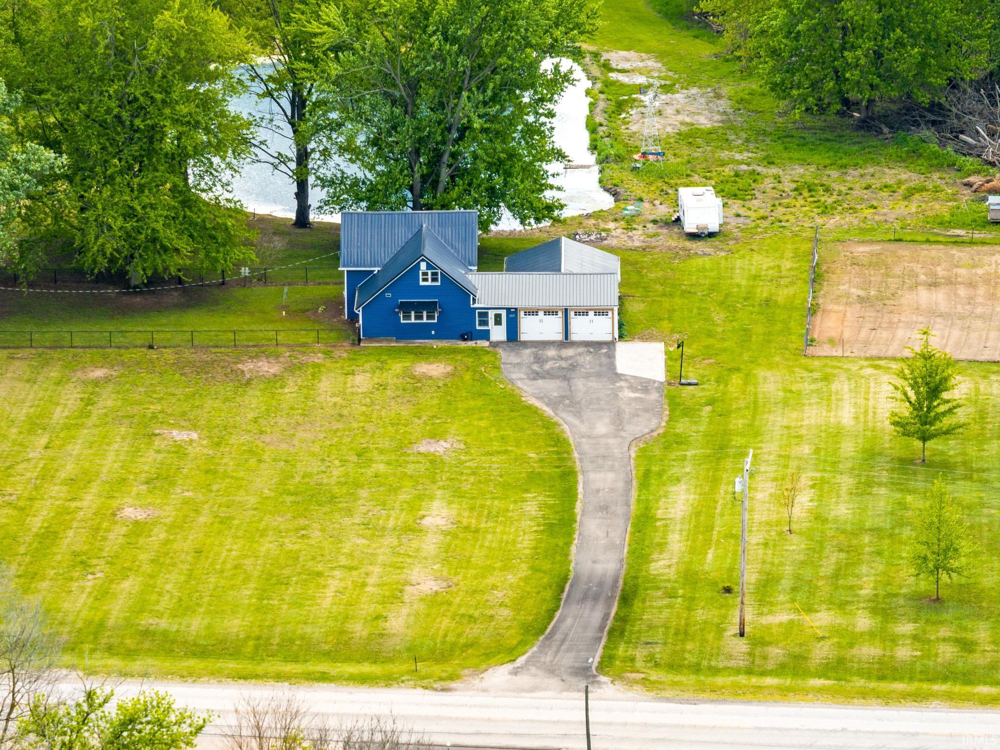 Blue residence featuring a metal roof and an attached two-car garage