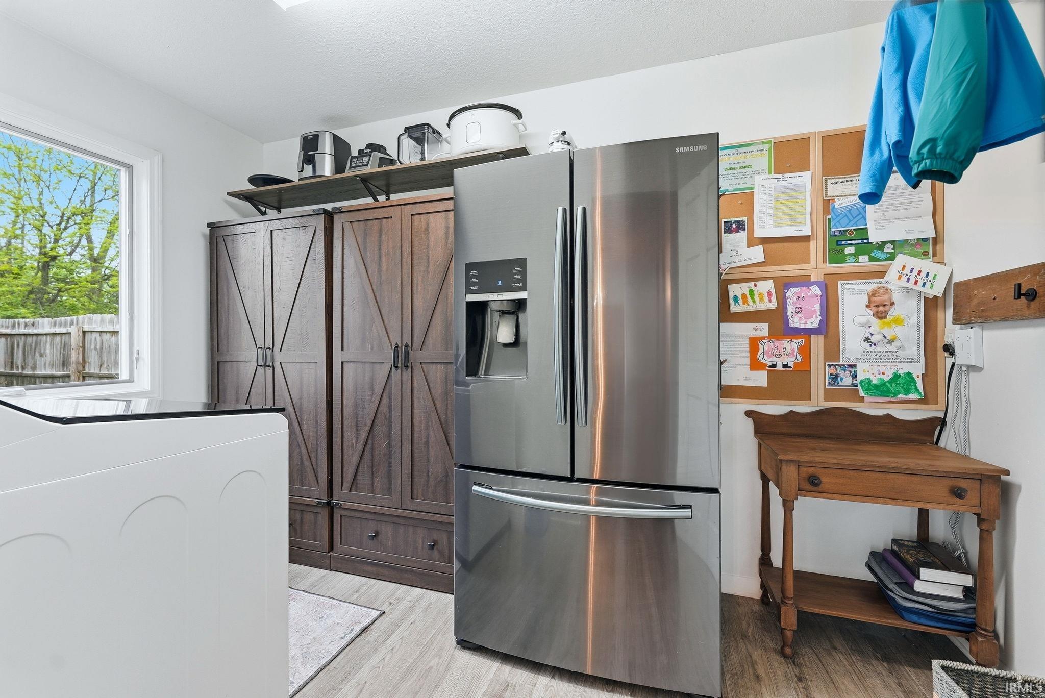 Light wood-finish flooring complements white walls in this utility space