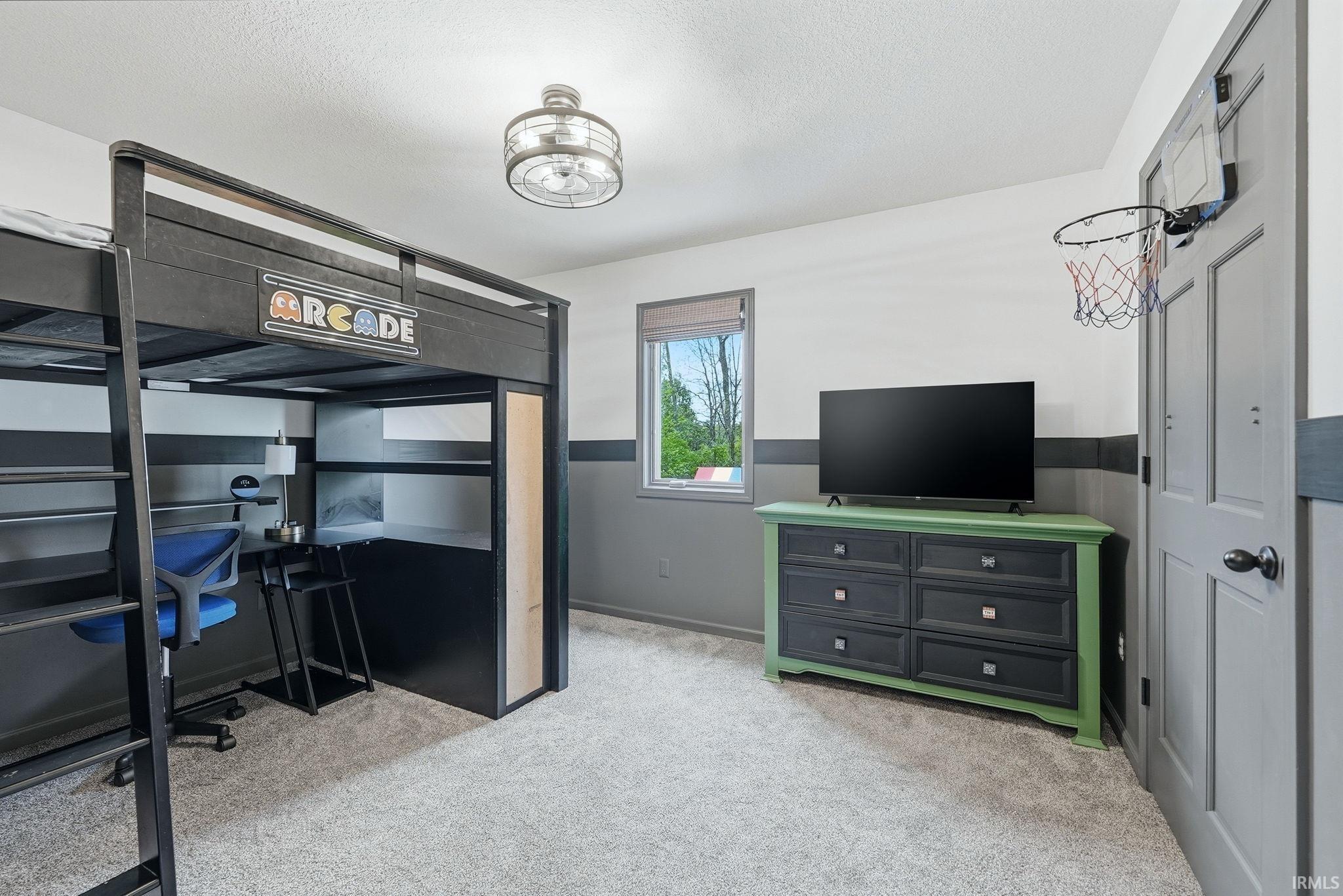 Carpeted room featuring a loft bed with integrated desk space, a six-drawer dresser, and a window with natural light