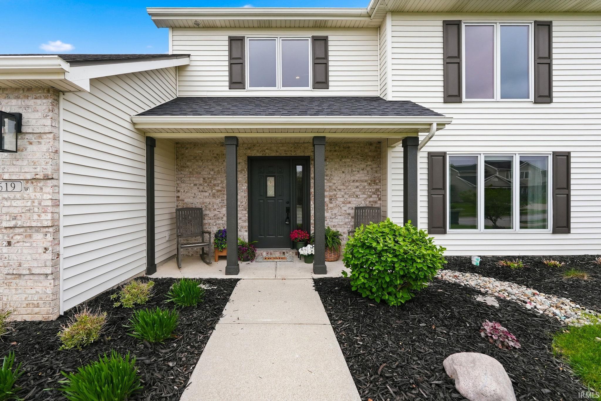 Two-story exterior with light-colored siding and brick accents