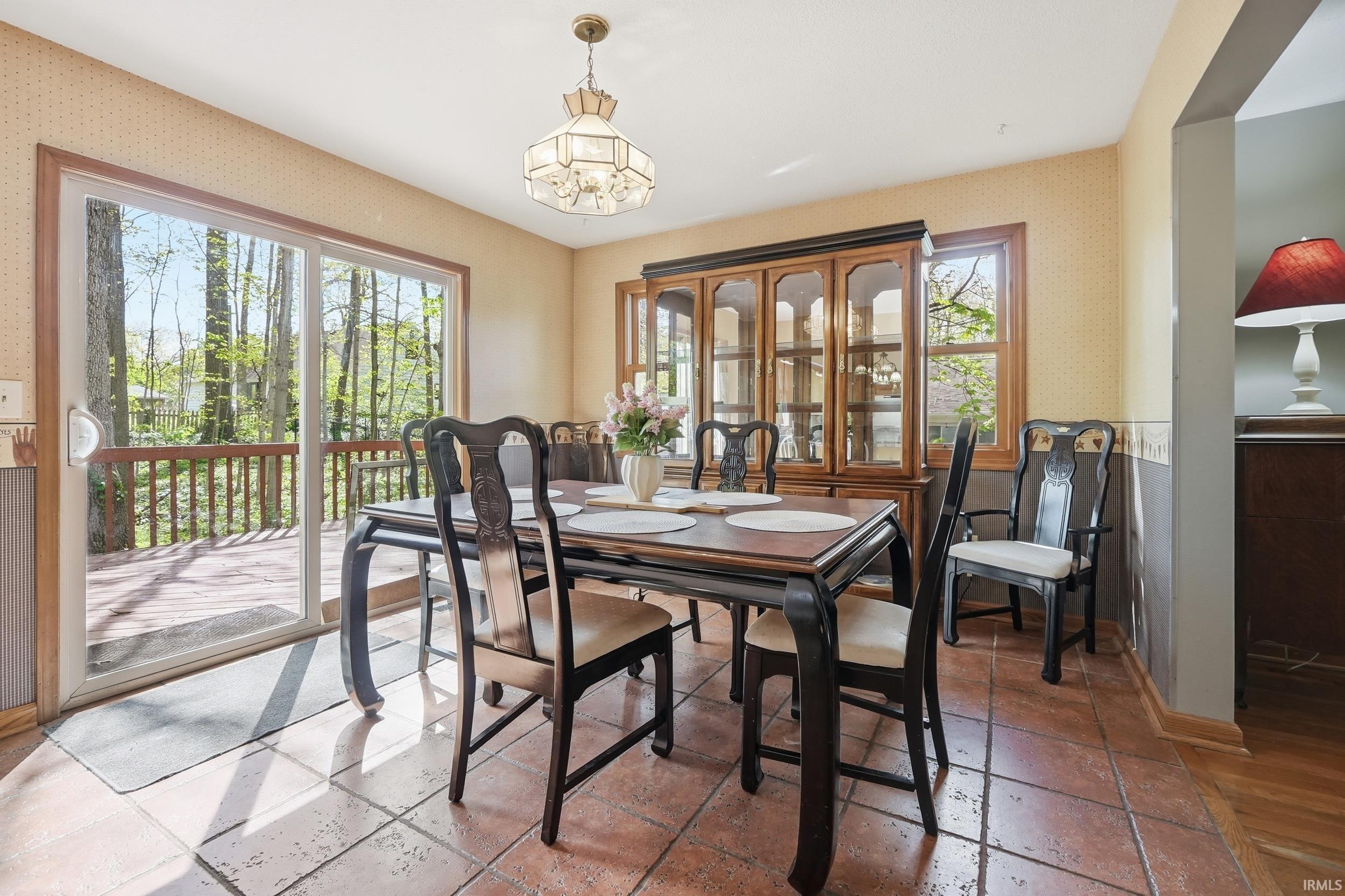 Dining area with tile flooring and a sliding glass door leading to a wooden deck