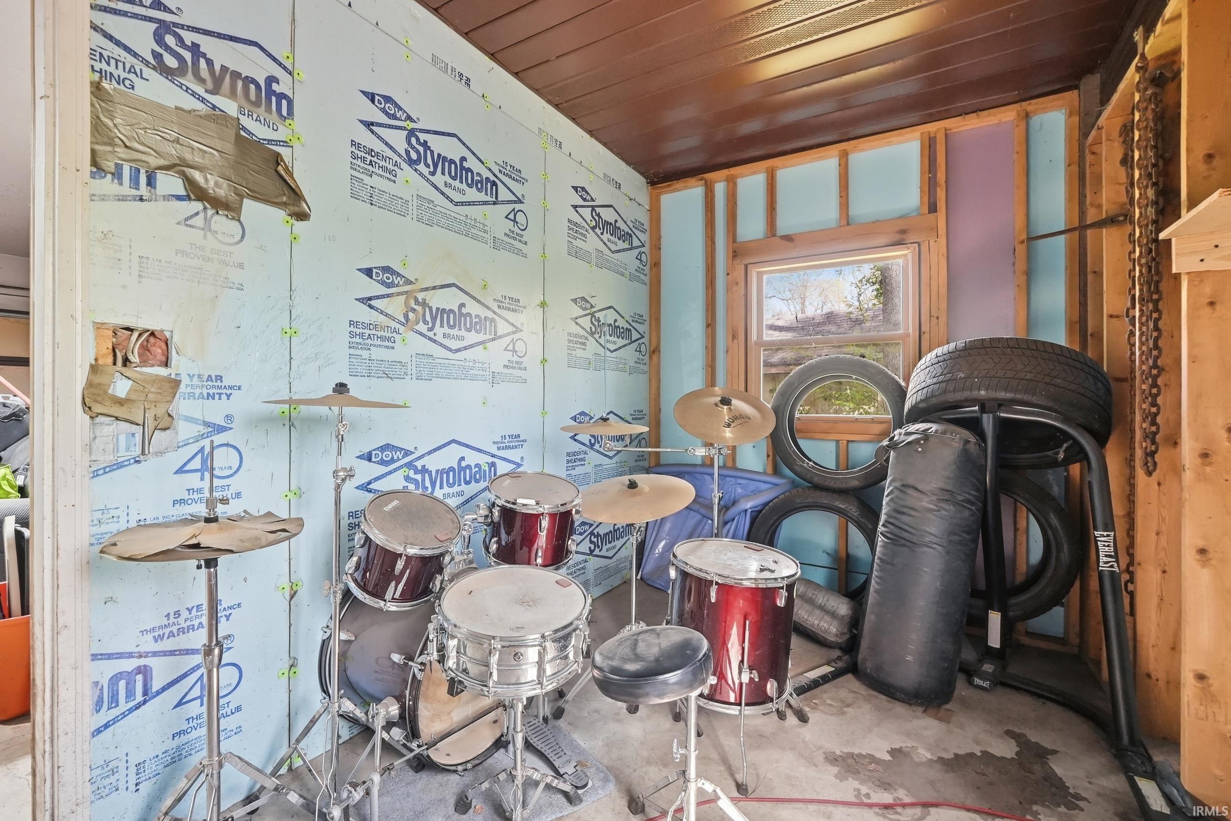 Space featuring exposed wooden framing, Styrofoam insulation, and a concrete floor