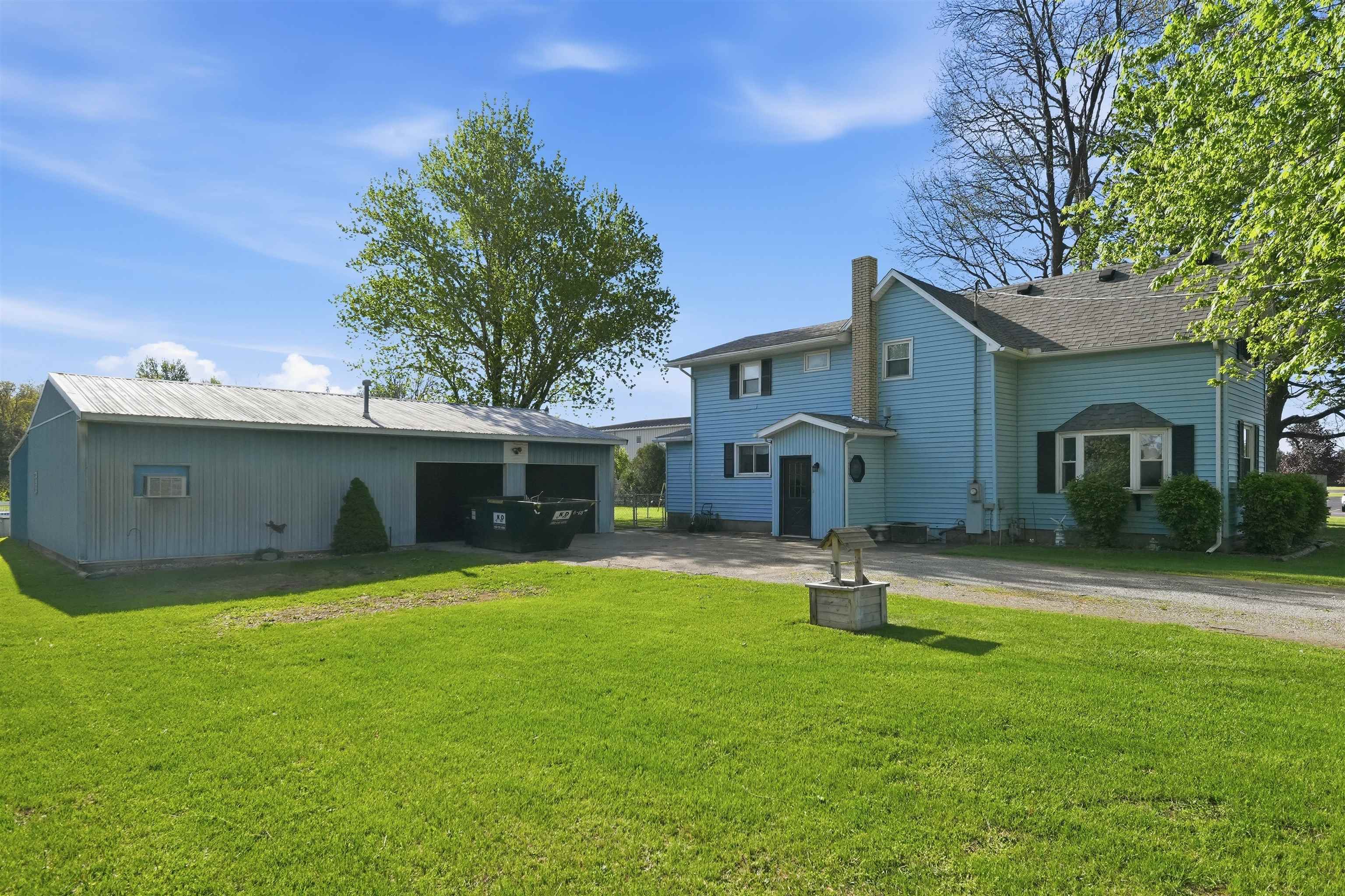 Two-story residence featuring blue siding, a dark roof, and a prominent chimney