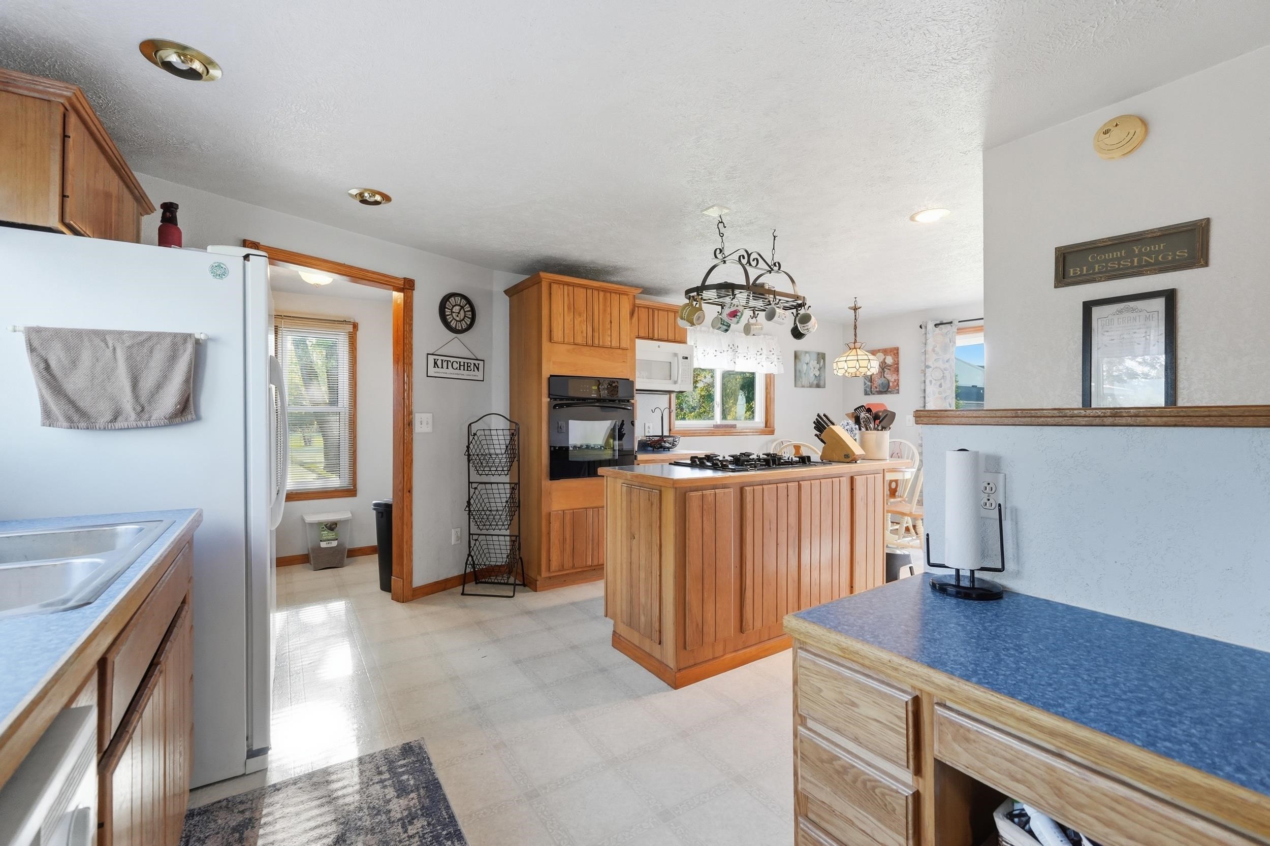Kitchen featuring light wood cabinetry and an island with a built-in cooktop
