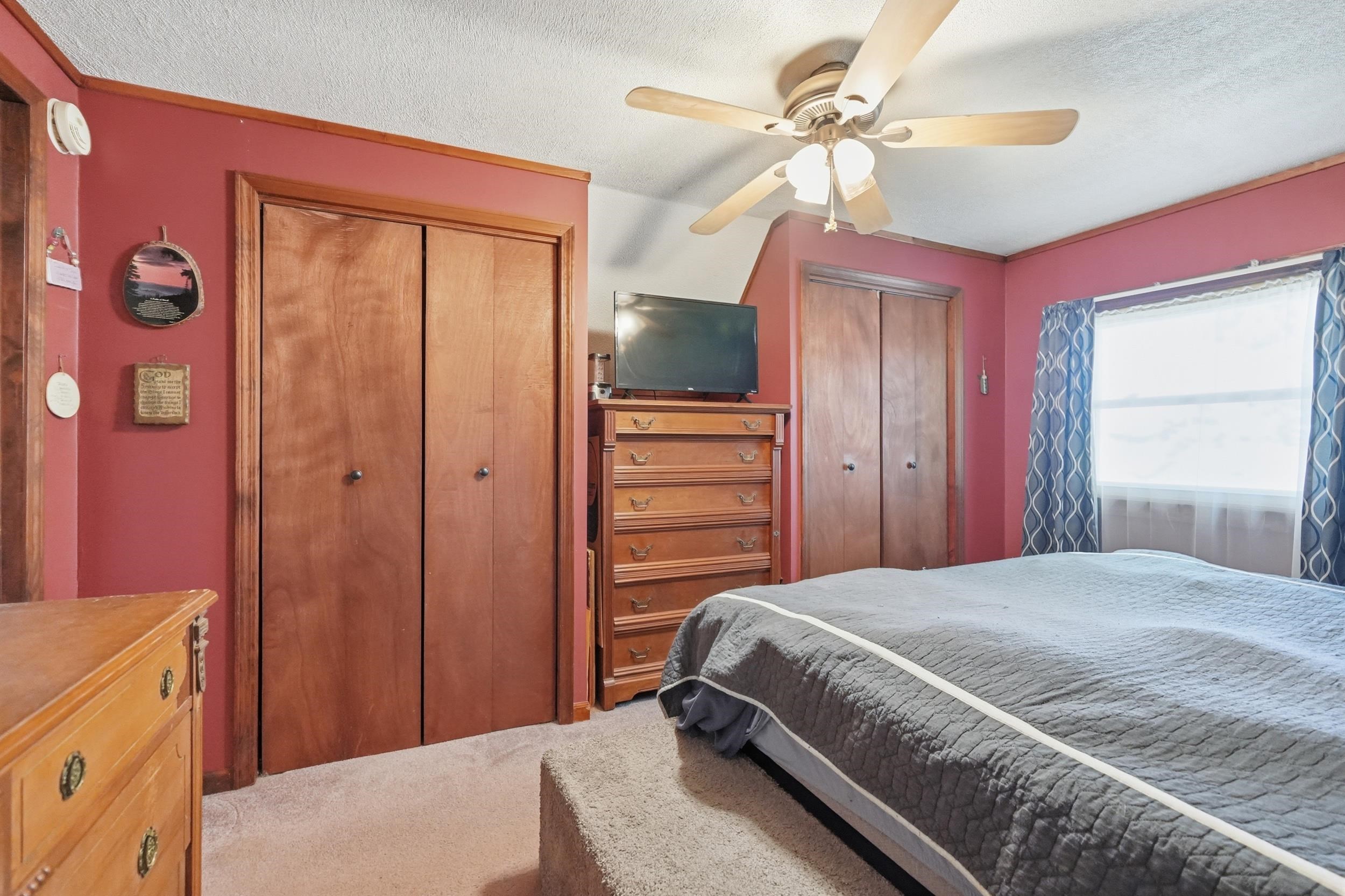 Neutral tone carpeting with light wood-finish bi-fold closet doors