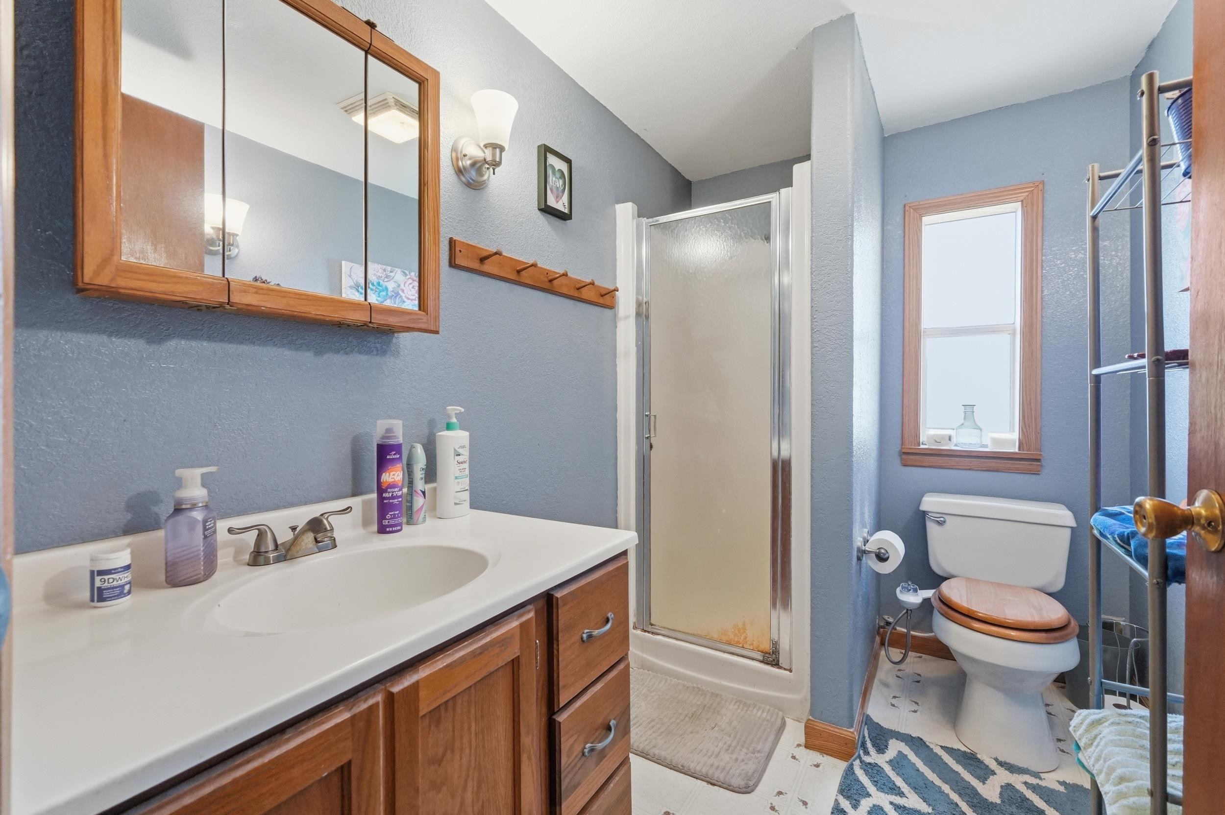 Bathroom featuring a single vanity with a white countertop and wood-finish cabinetry