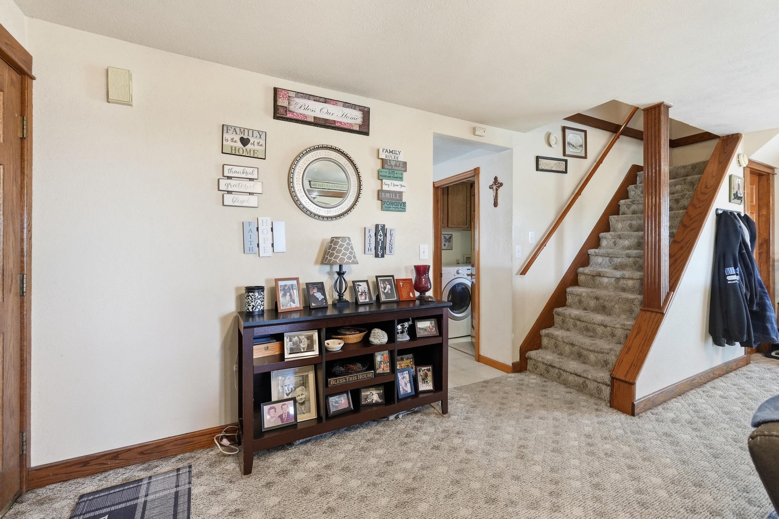 Staircase featuring wood railings and carpeted treads