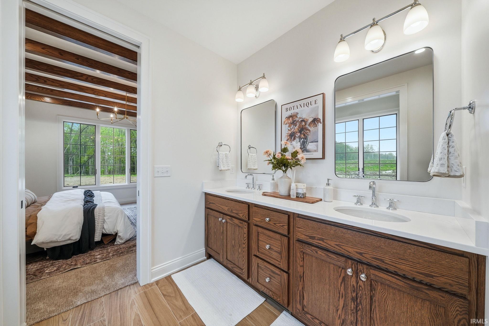Double vanity featuring wood-finish cabinetry, white countertops, and dual vessel sinks with chrome fixtures