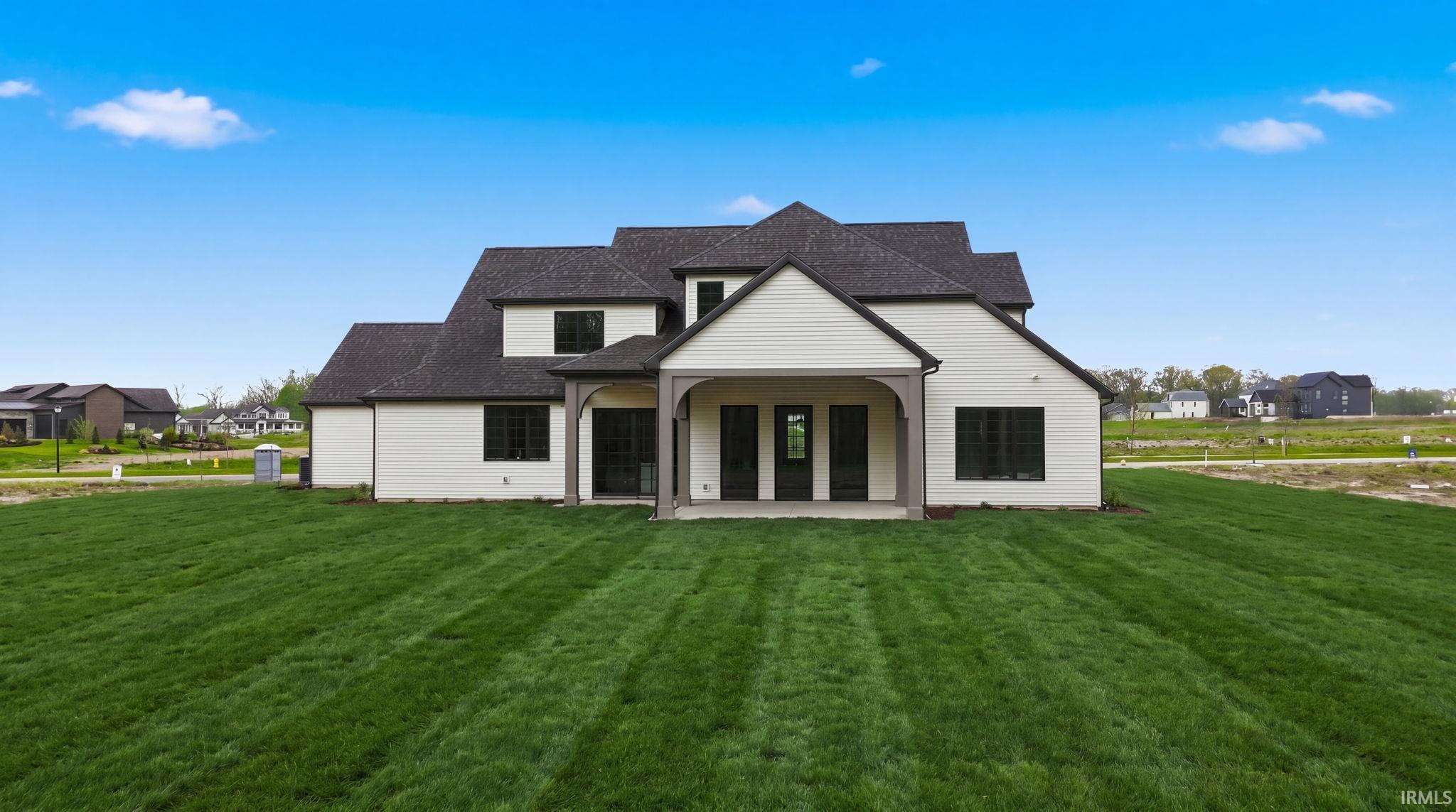 Rear exterior showcasing a covered patio with dark wood-finish columns