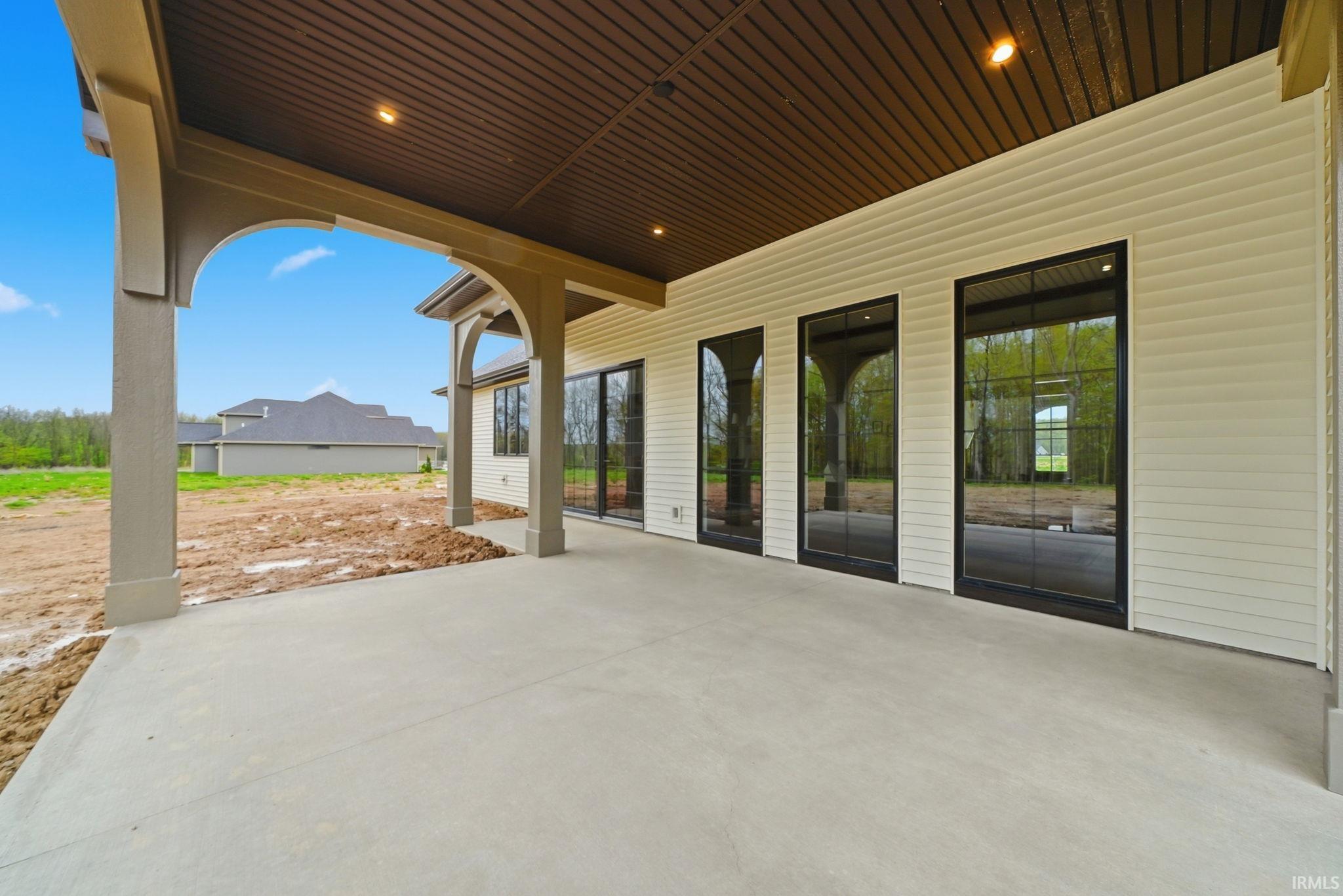 Expansive covered patio featuring a concrete surface, recessed lighting, and a detailed wood-finish ceiling