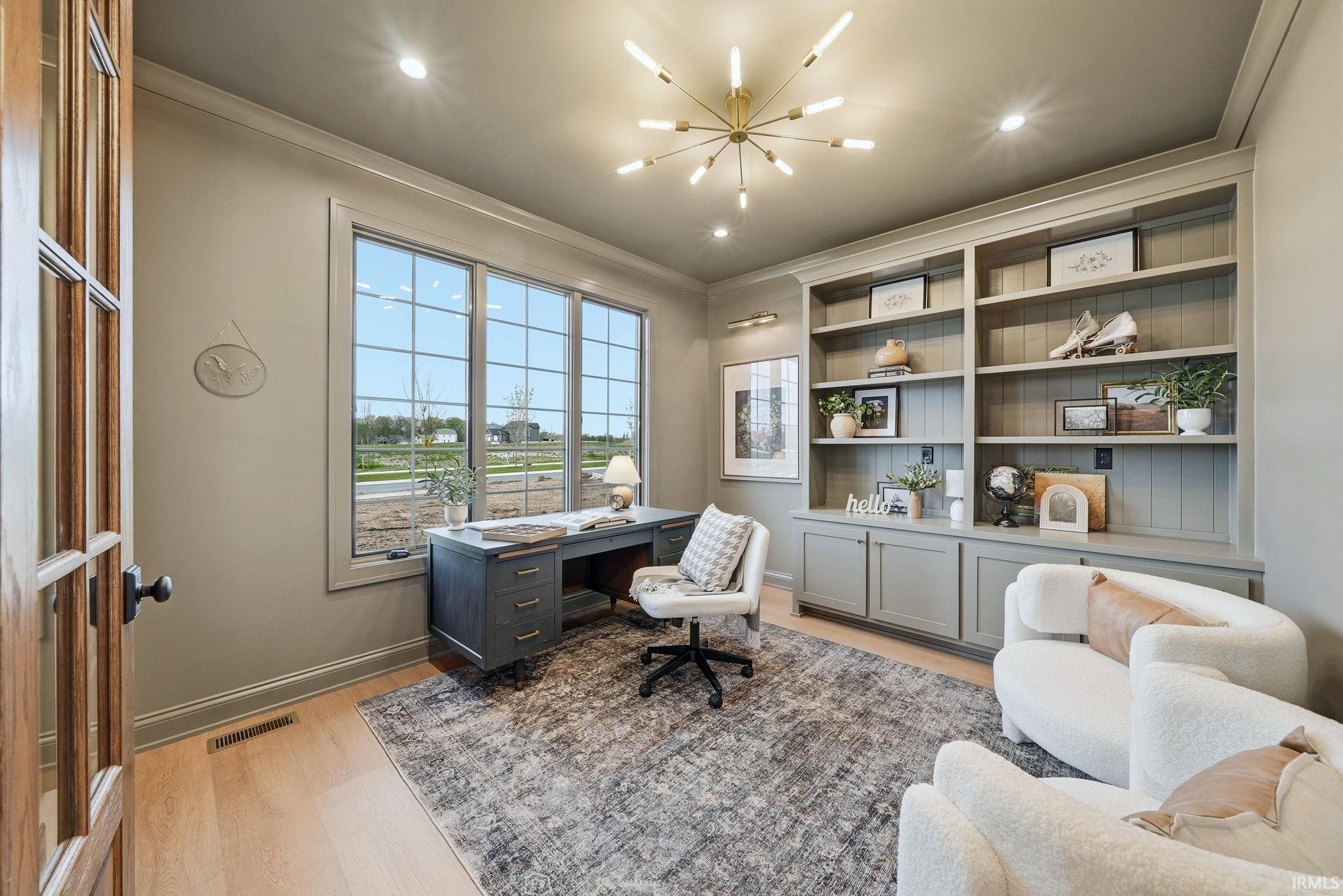 Dedicated space featuring light wood-finish flooring and a contemporary chandelier