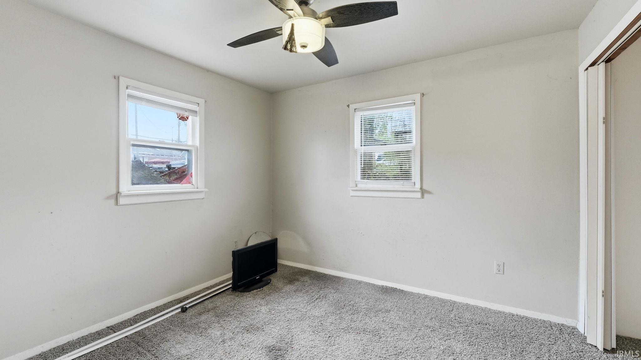 Neutral gray wall paint with two windows providing natural light