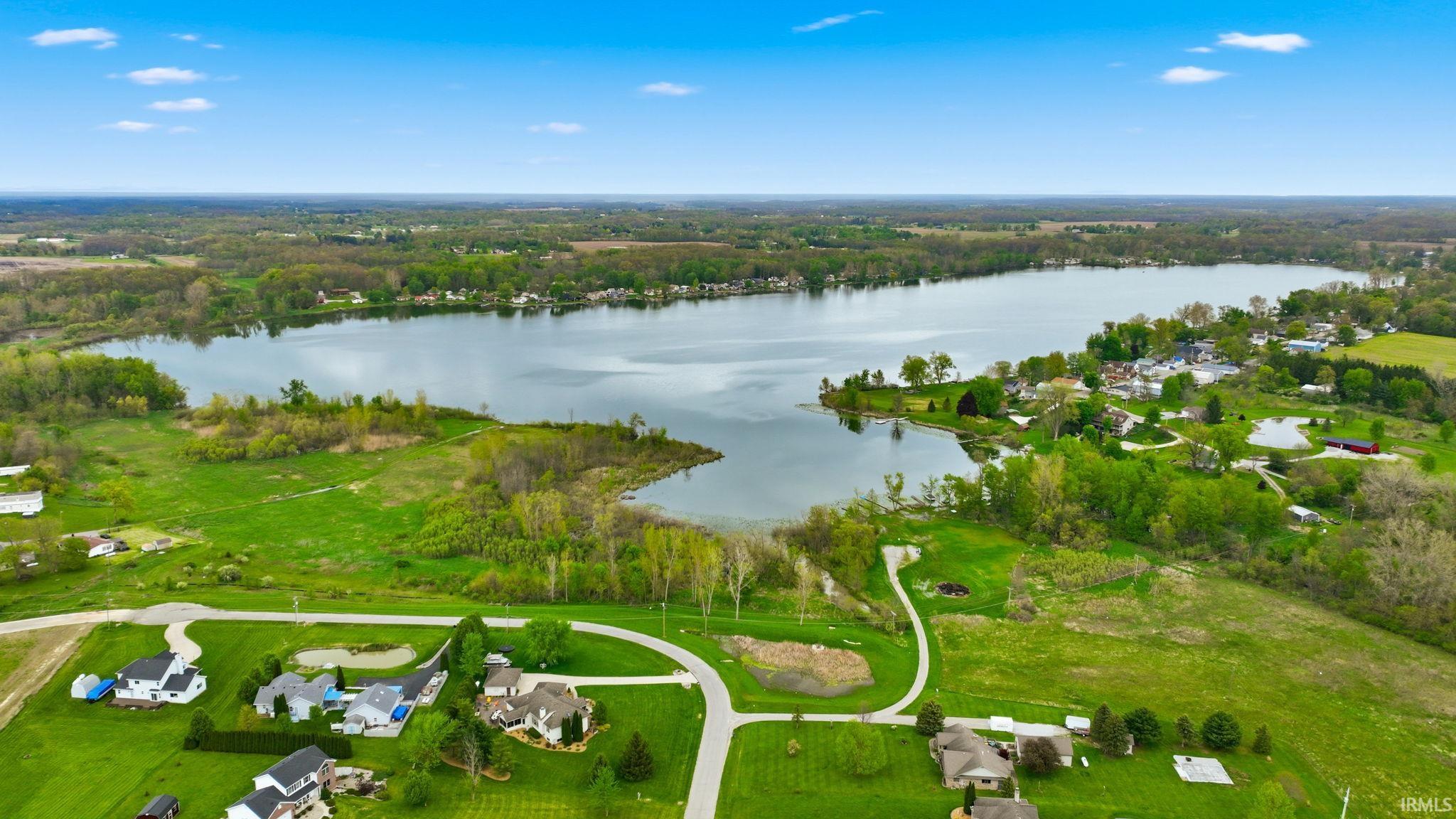 Expansive aerial capturing a large lake surrounded by lush green landscapes