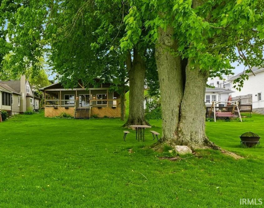 Expansive green lawn with mature trees providing shade