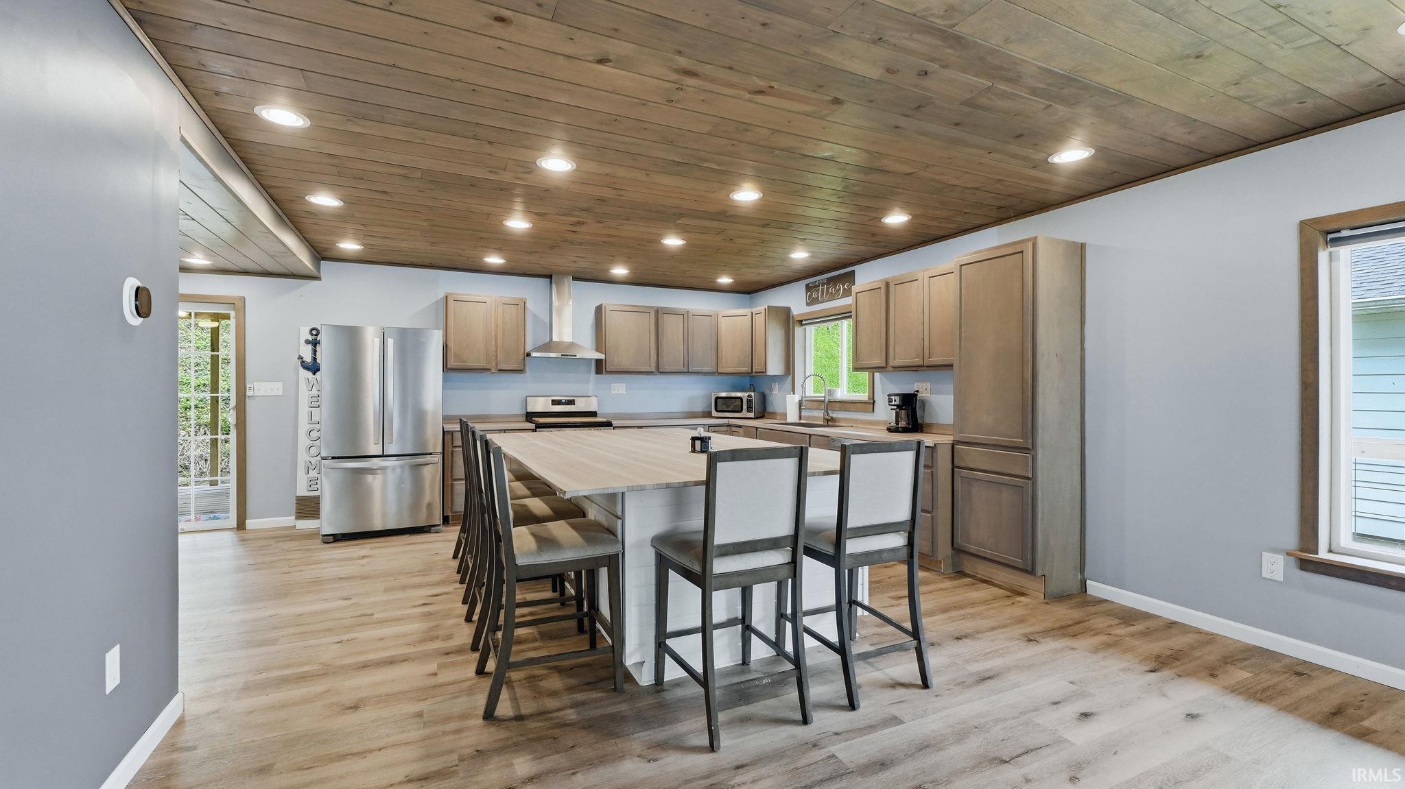 Kitchen with wood-finish flooring and a wood plank ceiling featuring recessed lighting