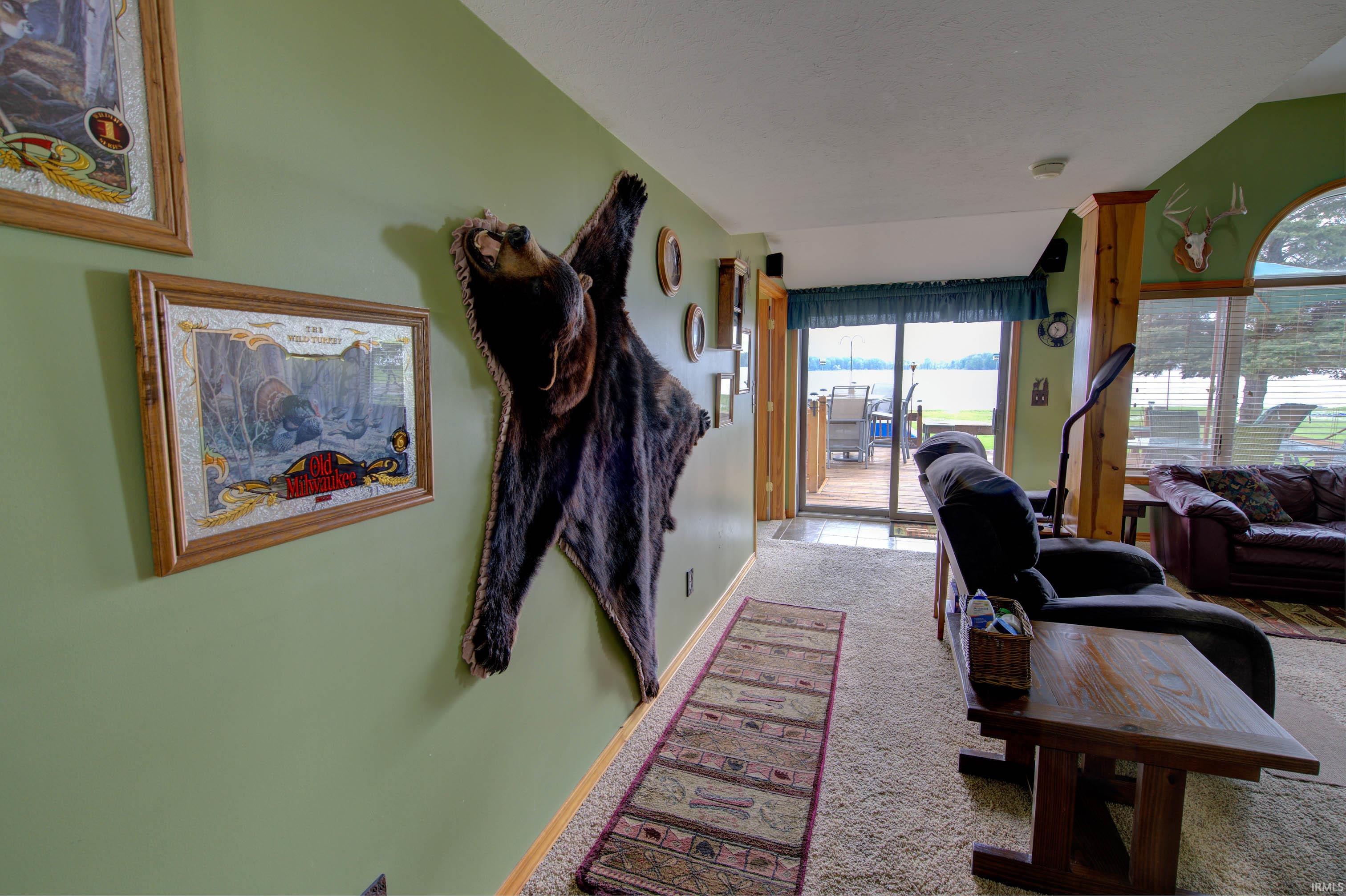 Spacious interior with carpet flooring and direct access to an outdoor deck