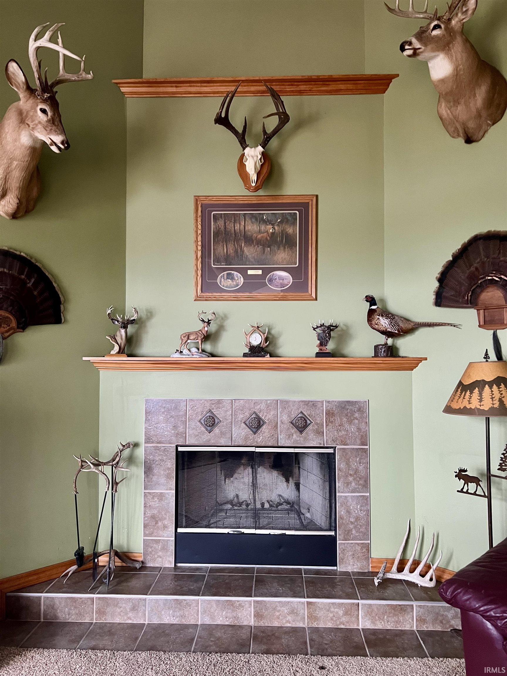 Fireplace featuring a tiled surround with decorative accents and a raised hearth