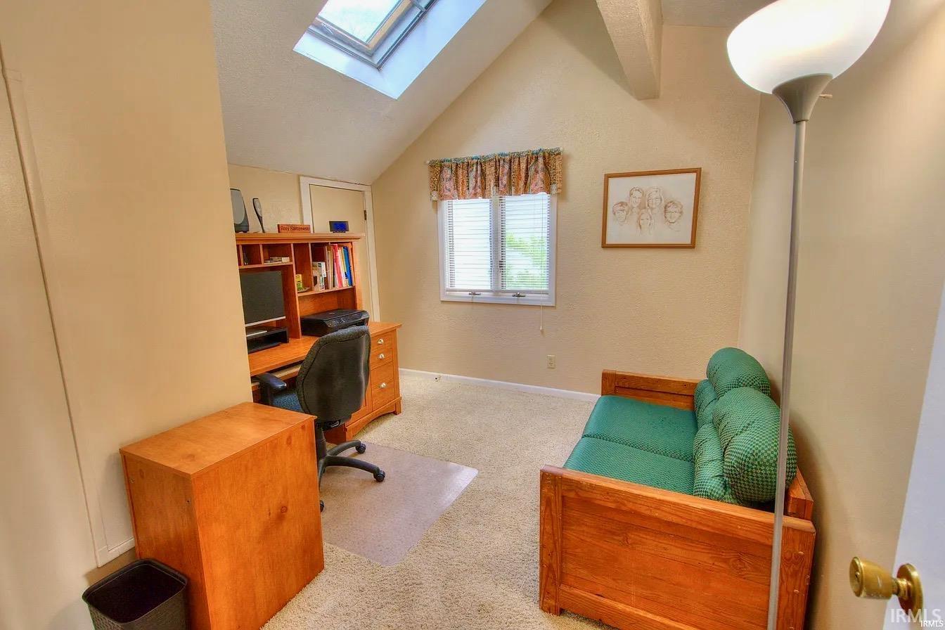 Vaulted ceiling with skylight and wood-finish support beam