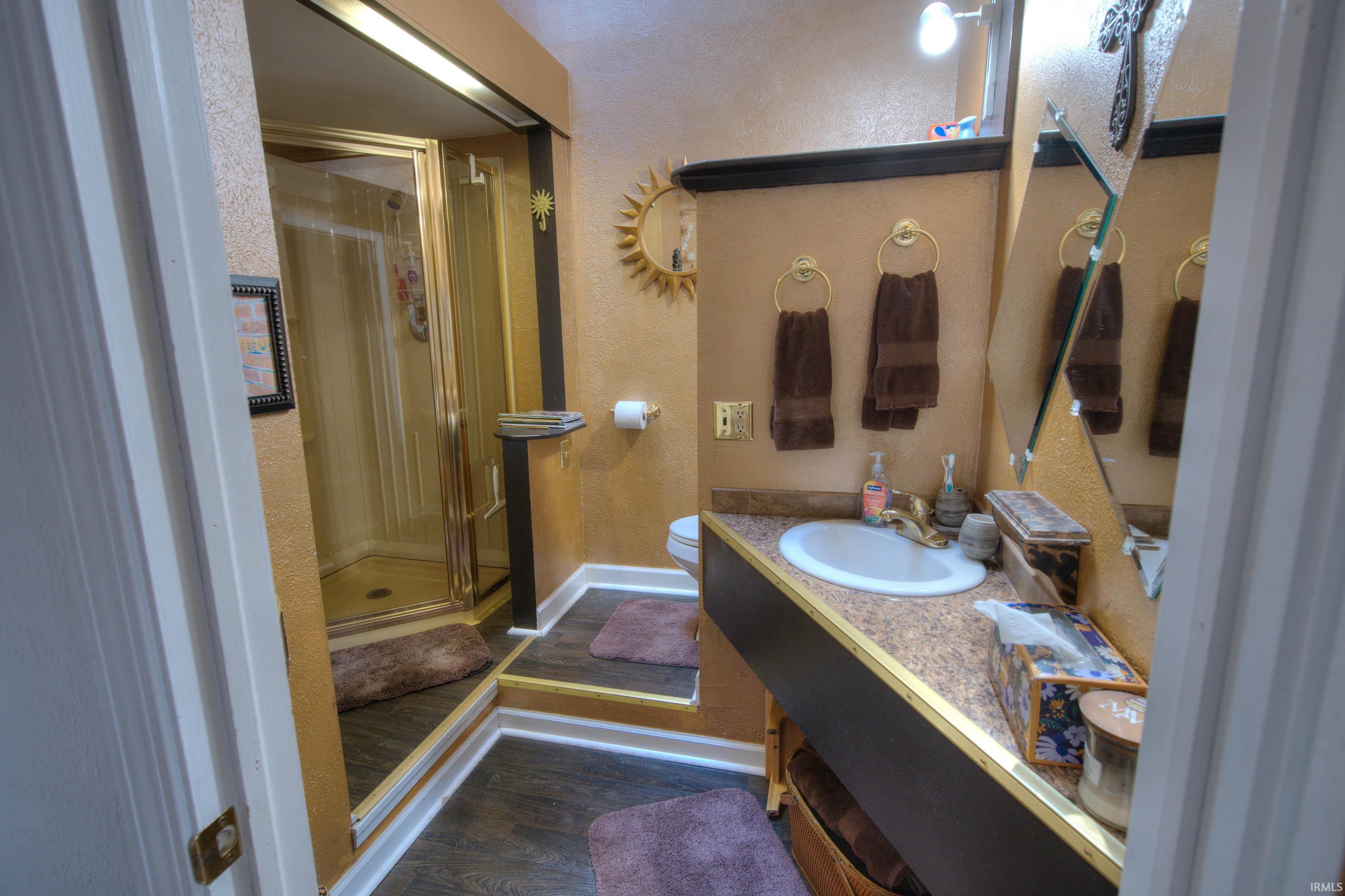 Bathroom vanity with an integrated sink and gold-tone faucet, set against a textured wall