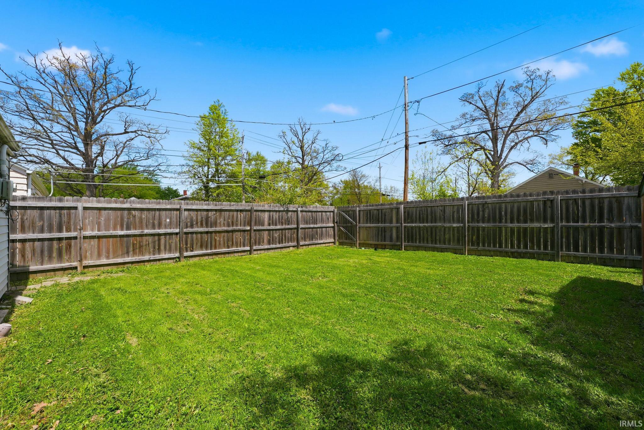 Expansive fenced backyard featuring a grassy lawn