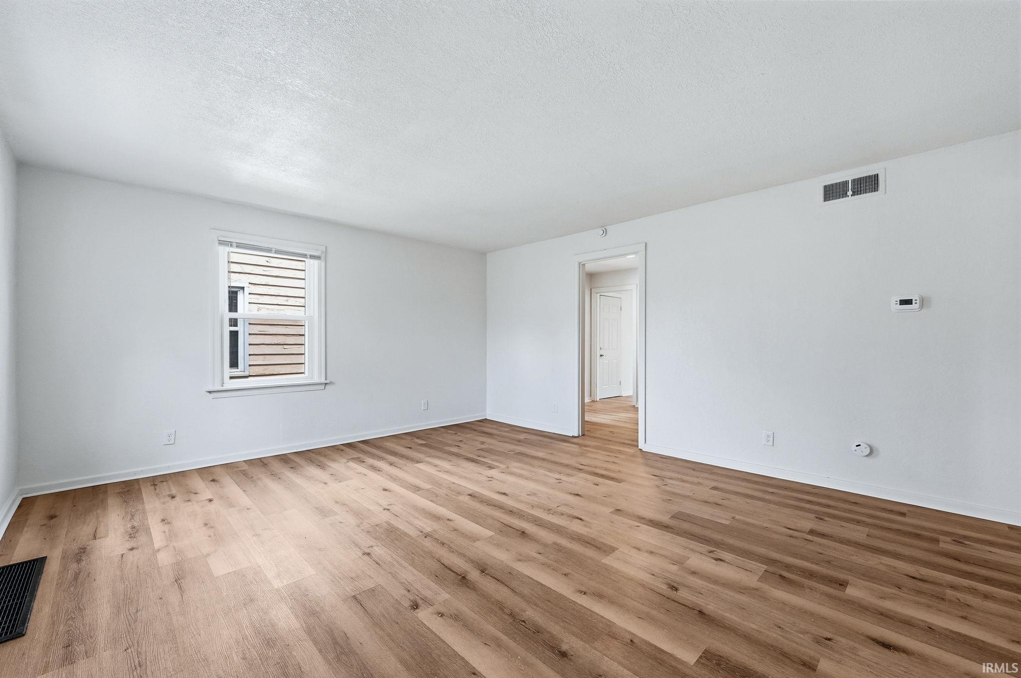 Spacious interior with wood-finish flooring and crisp white walls